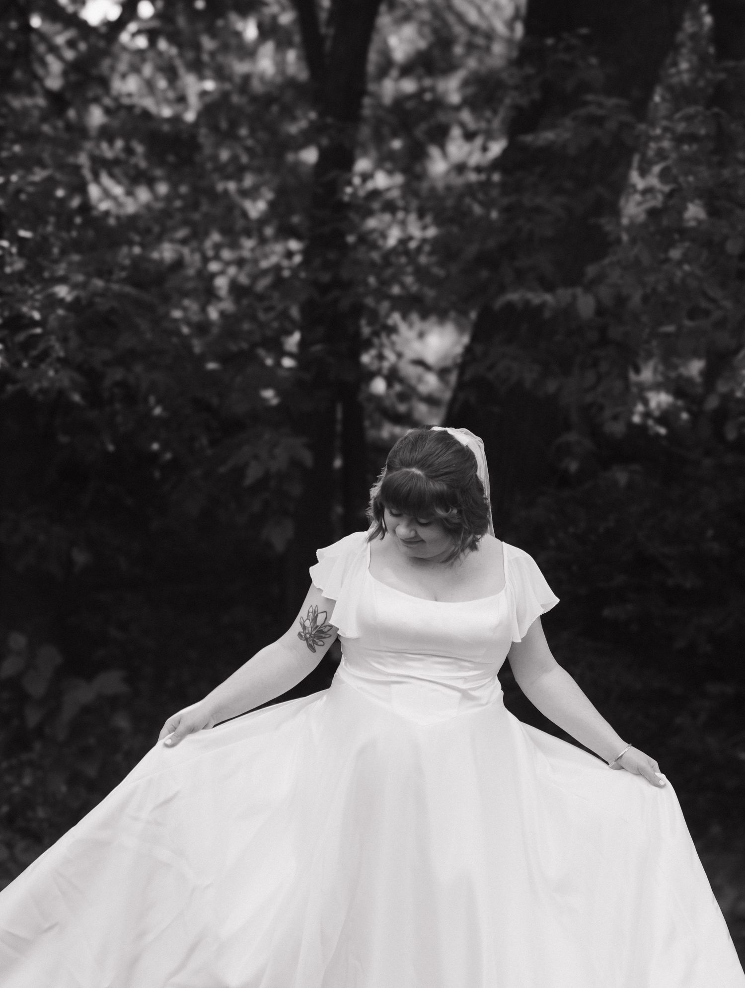 Black and white detail shot of a flowing white wedding dress.