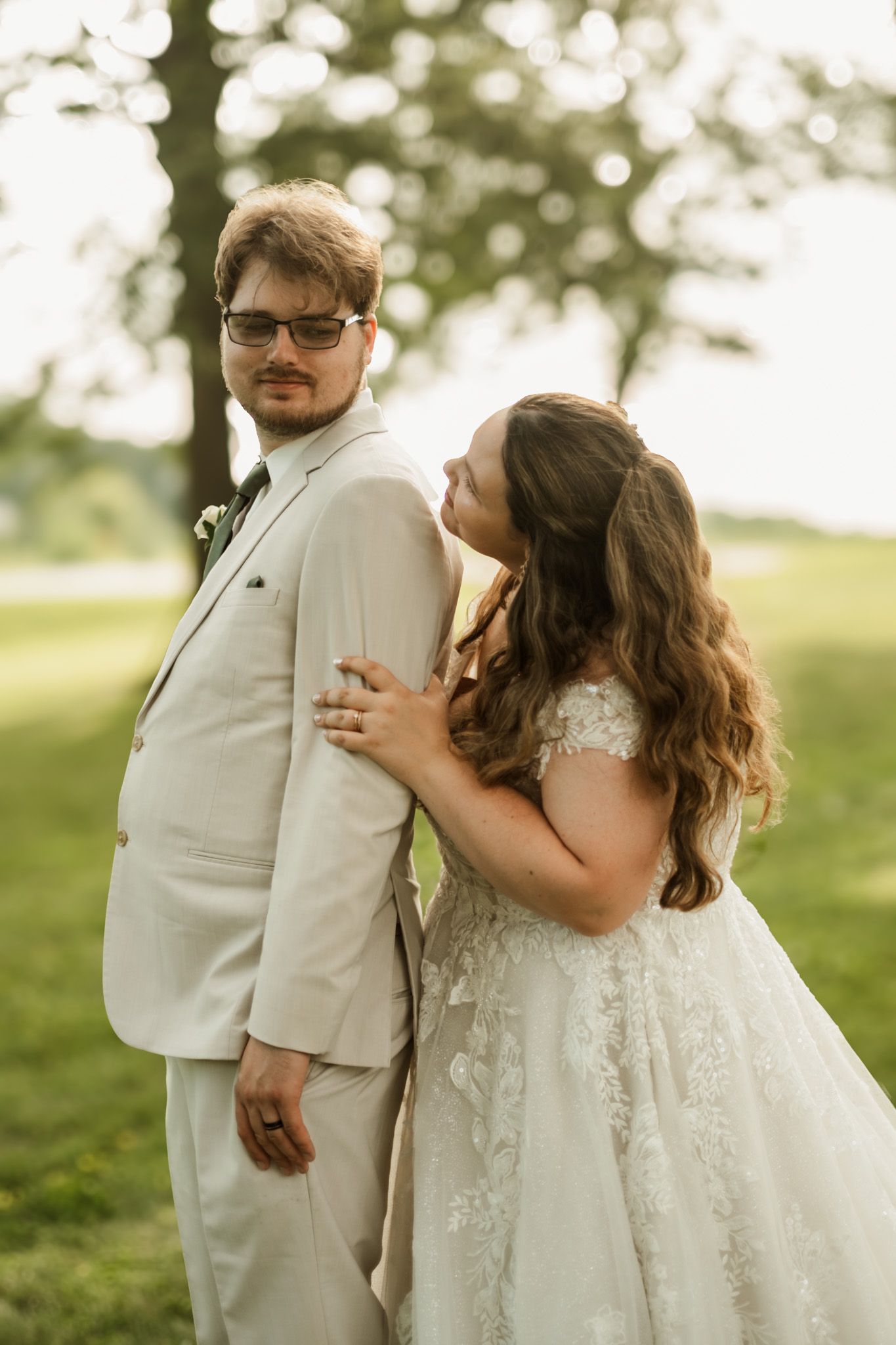 Couple embracing during outdoor wedding portraits in natural lighting.