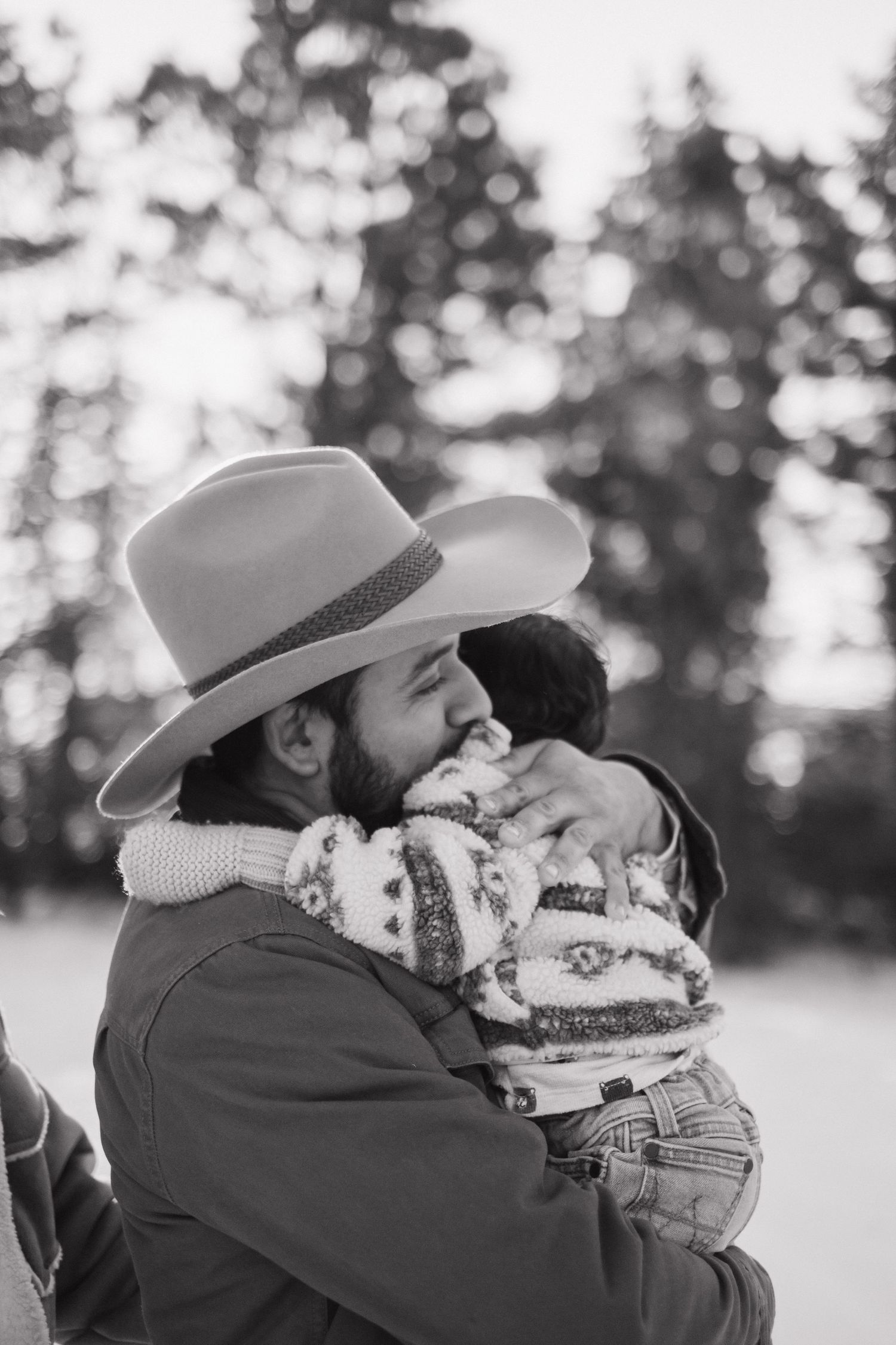 Intimate family portraits in black and white against a snowy winter forest backdrop.