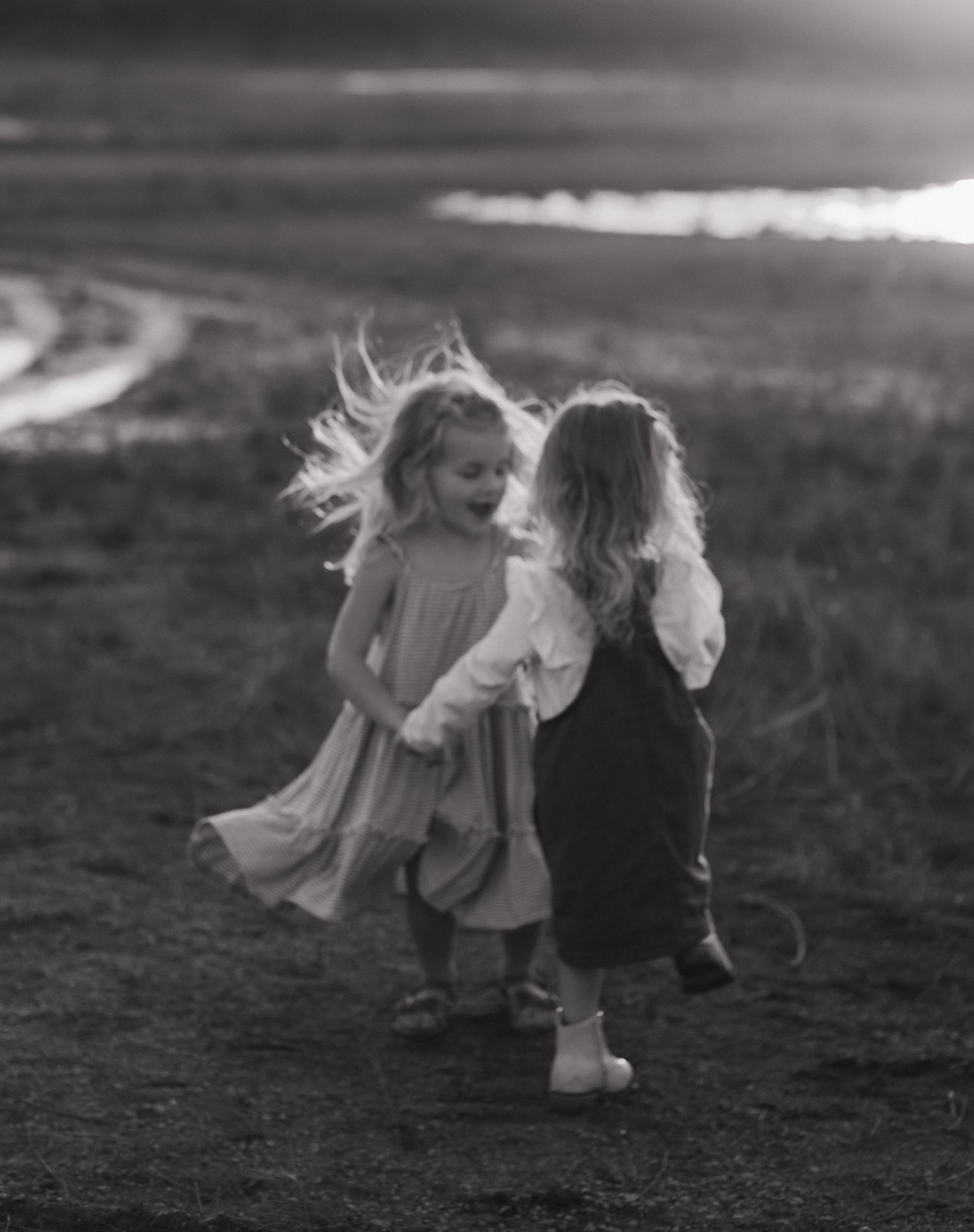 Black and white photo of children playing outdoors in a field.