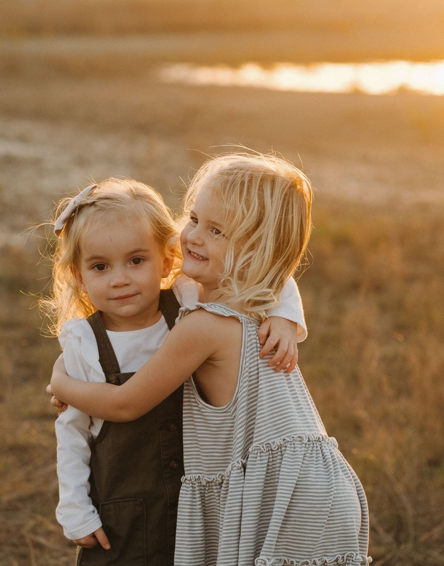 Two young children sharing a sweet moment together at sunset.