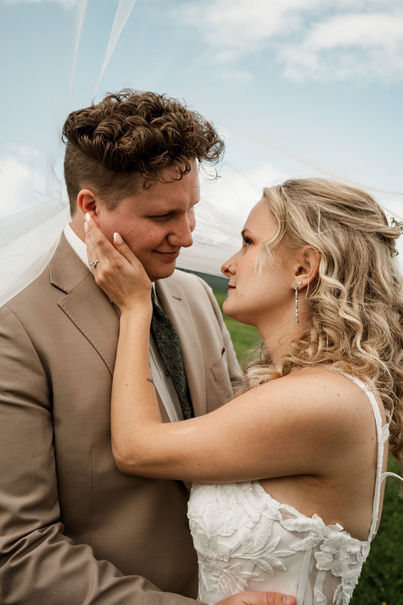 Close-up wedding photos showing tender romantic moments against a bright blue sky.