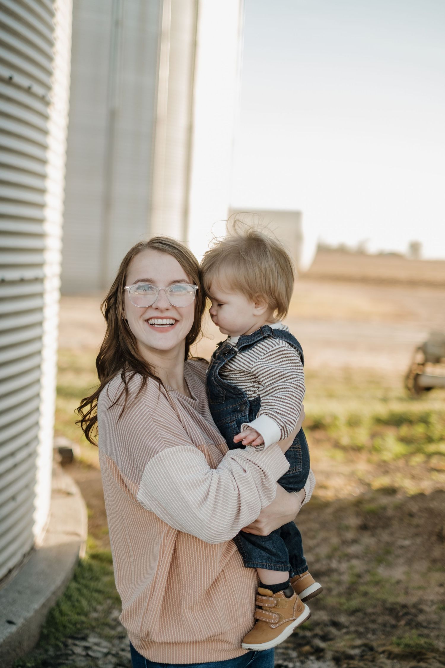 Candid family moments captured in warm sunlight against rustic building exterior.