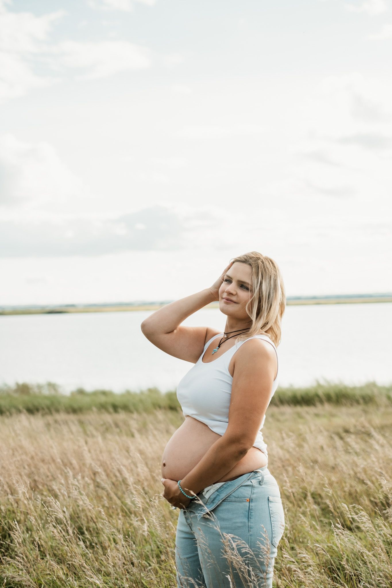 Maternity photos taken in a golden field during sunset.