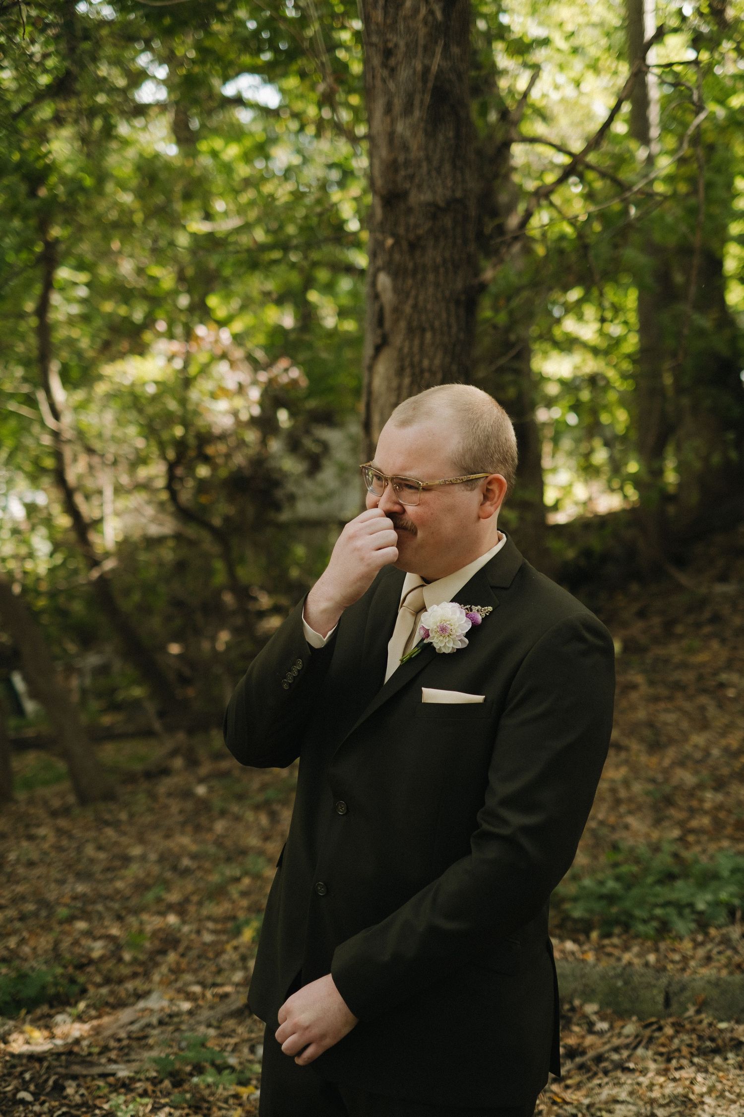 An emotional moment captured in a wooded setting during a wedding ceremony.