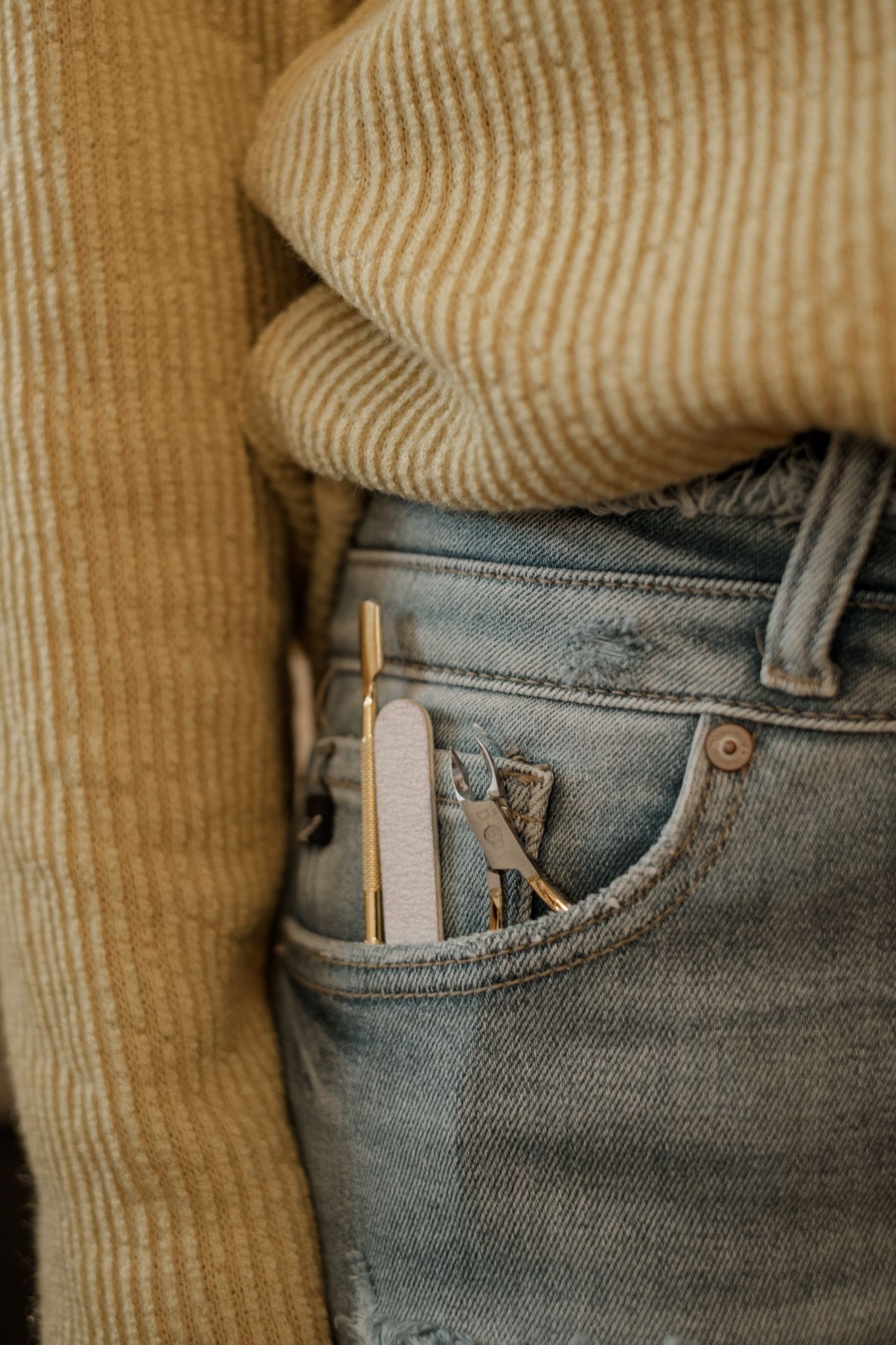 Close-up of wooden clothespins clipped onto the pocket of light blue denim jeans.