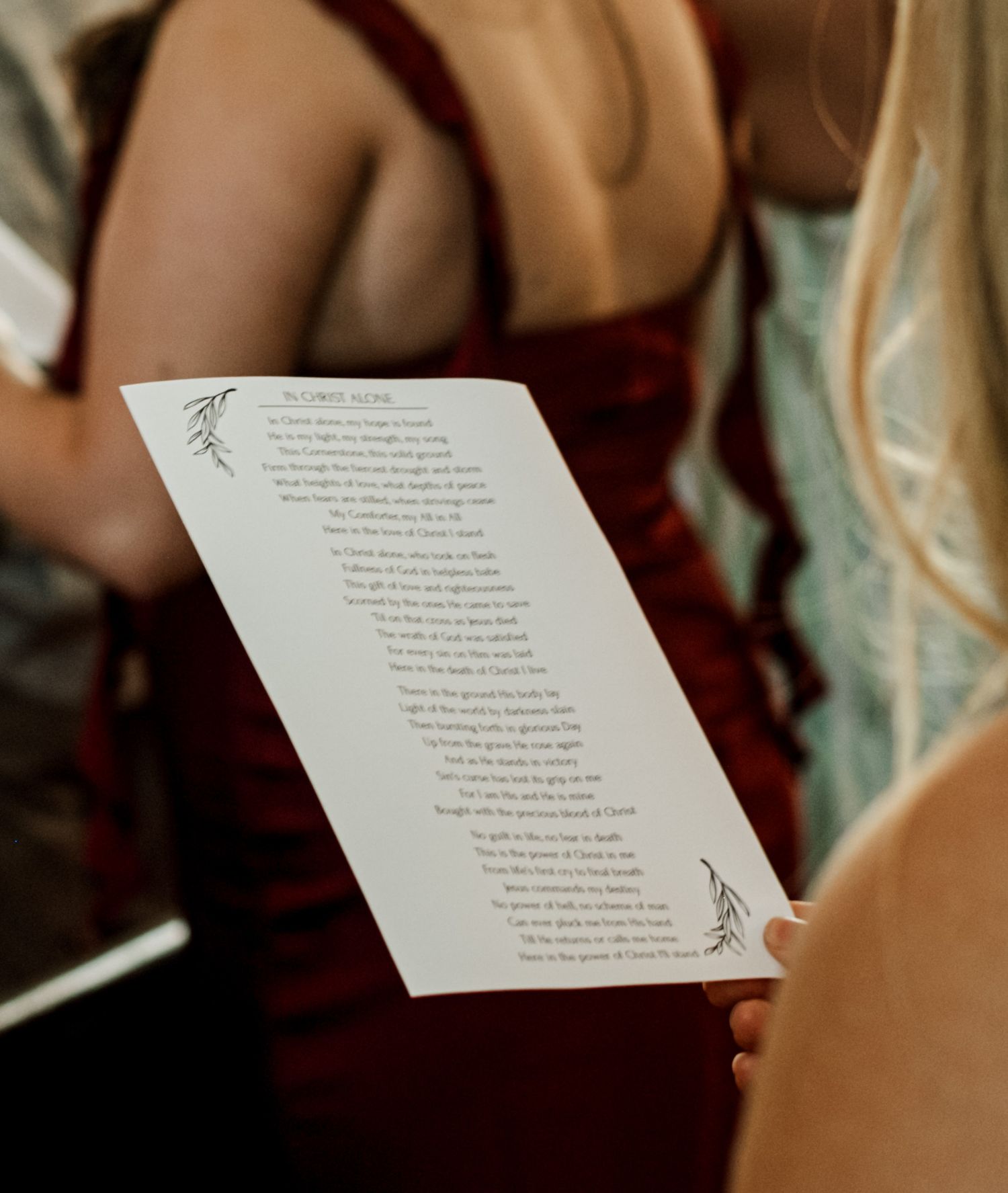 Wedding ceremony program held by guest during indoor service.