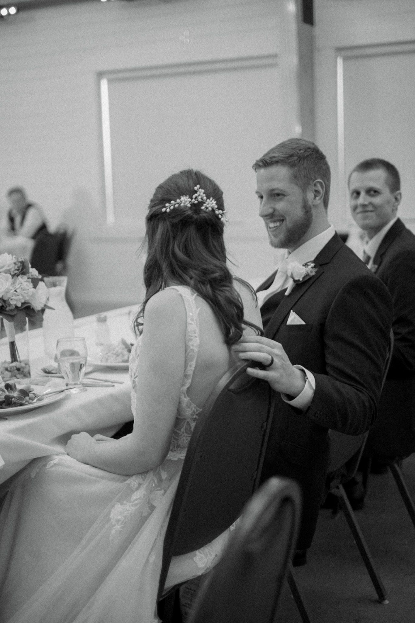 Wedding reception guests seated at tables during dinner and toasts.