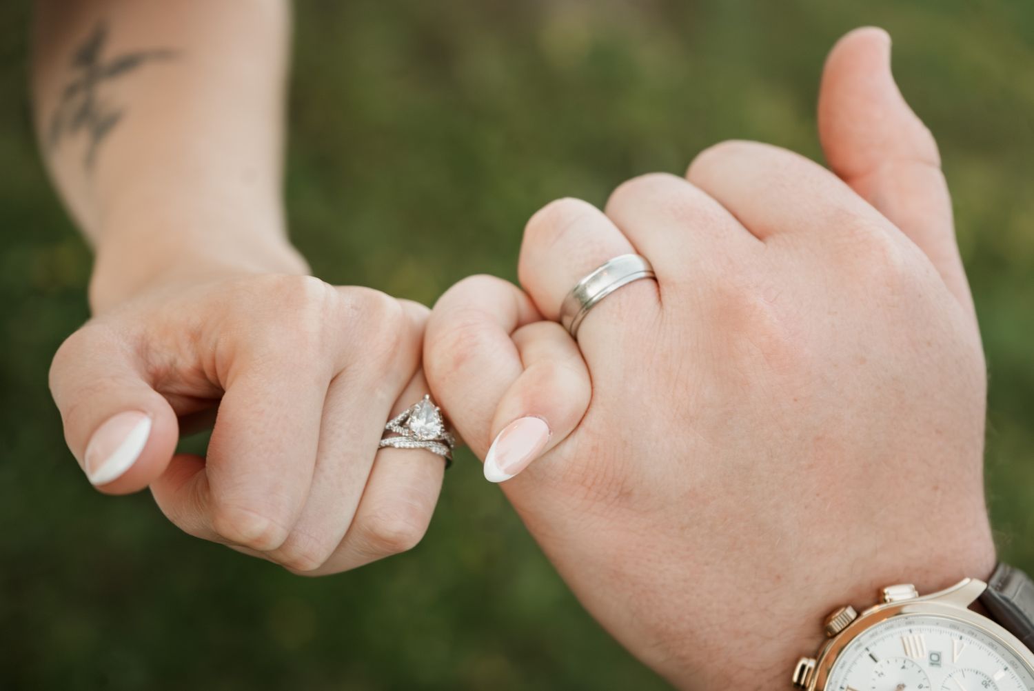 Close-up of hands wearing wedding rings showing the intricate details of the jewelry.