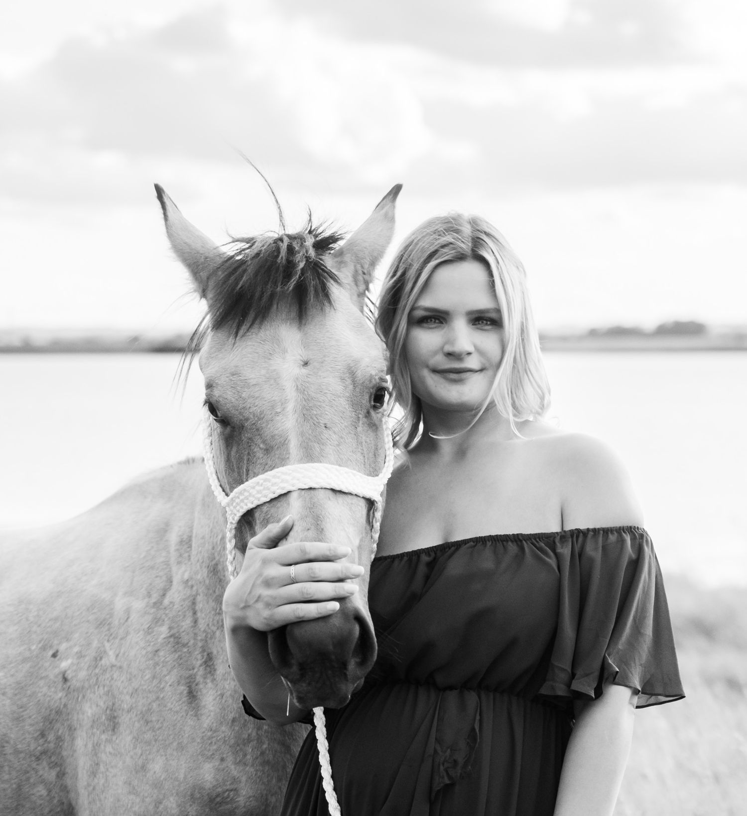 A horse and person share intimate moments in black and white photography.