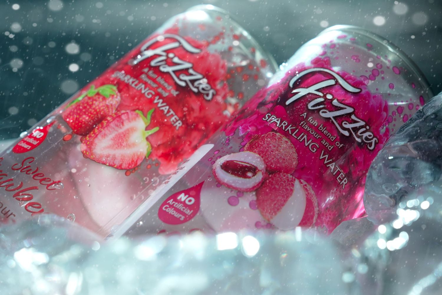 Two pink fizzy drinks in glass bottles chilling on ice with condensation.