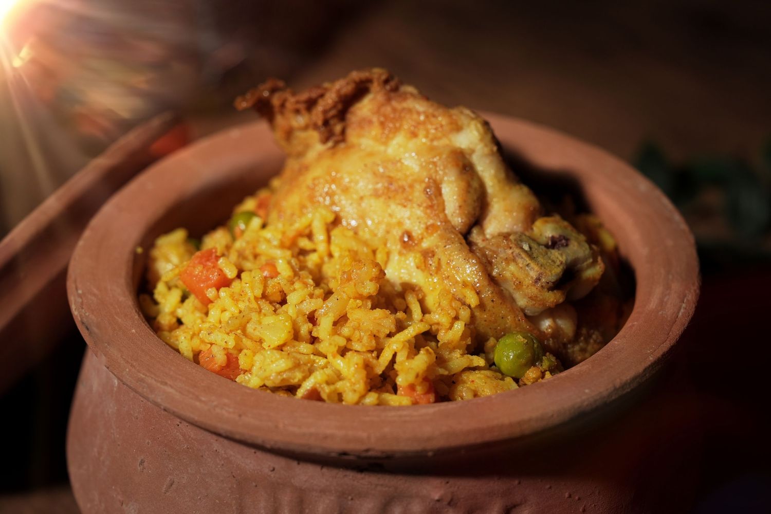 Fragrant biryani rice dish with chicken served in rustic earthen clay pot.