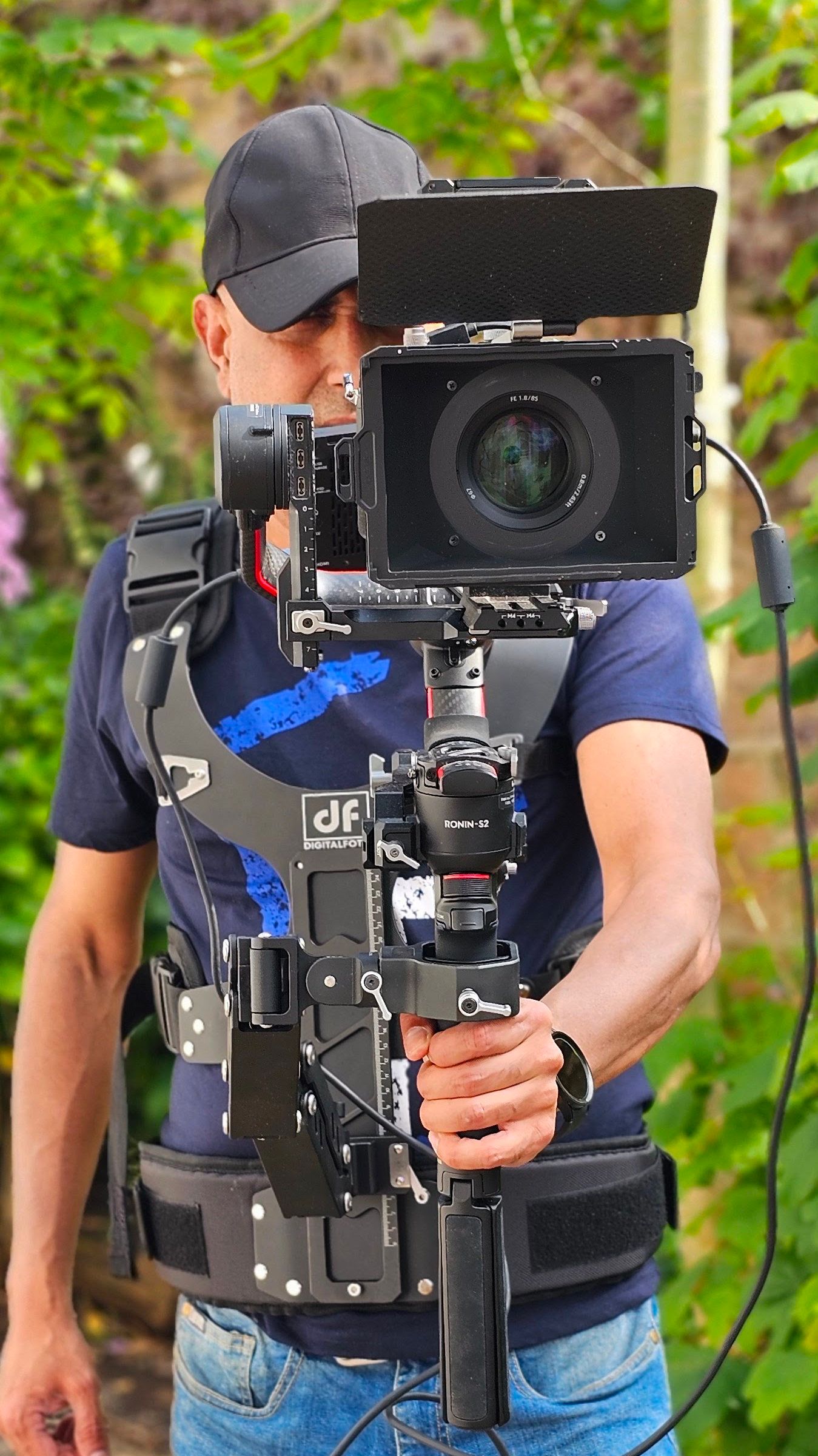 Professional camera operator using stabilized video equipment outdoors.