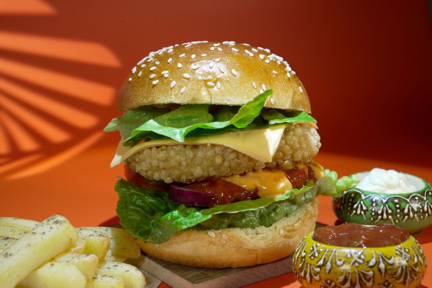Gourmet cheeseburger with fresh lettuce, tomato and sesame seed bun served with french fries.