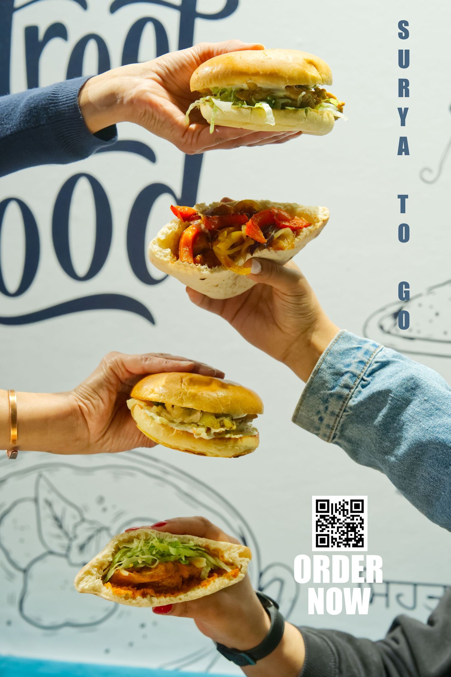 Hands holding juicy hamburgers with fresh toppings against a white and blue restaurant wall background.
