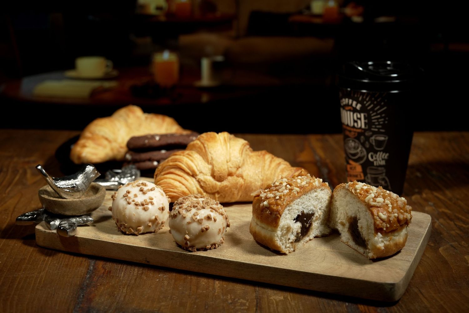 Artisanal cheese and bread platter displayed in moody lighting.