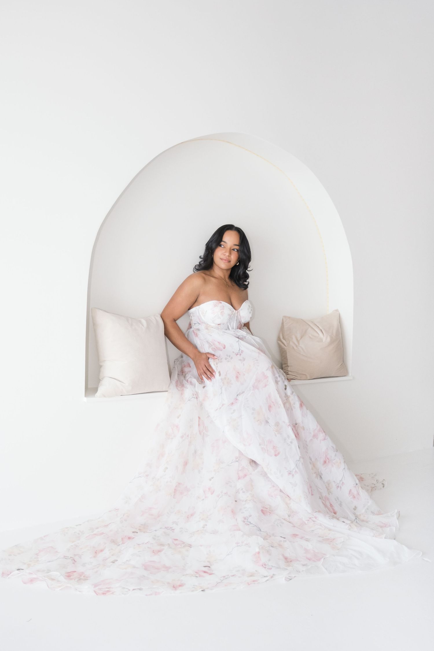 A stunning mother portrait series in white featuring a flowing floral gown against an arched white backdrop. cambridge uk photographer
