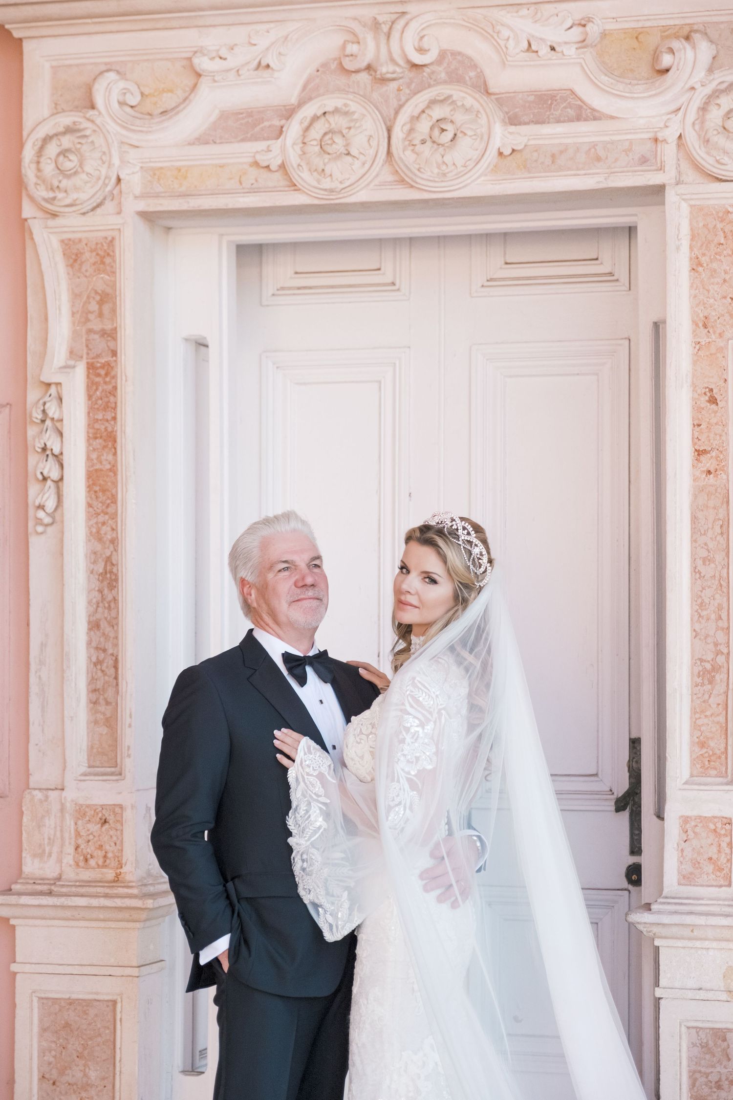 Wedding scene in an elegant white and pink room with ornate architectural details and decorative moldings. London uk photographer