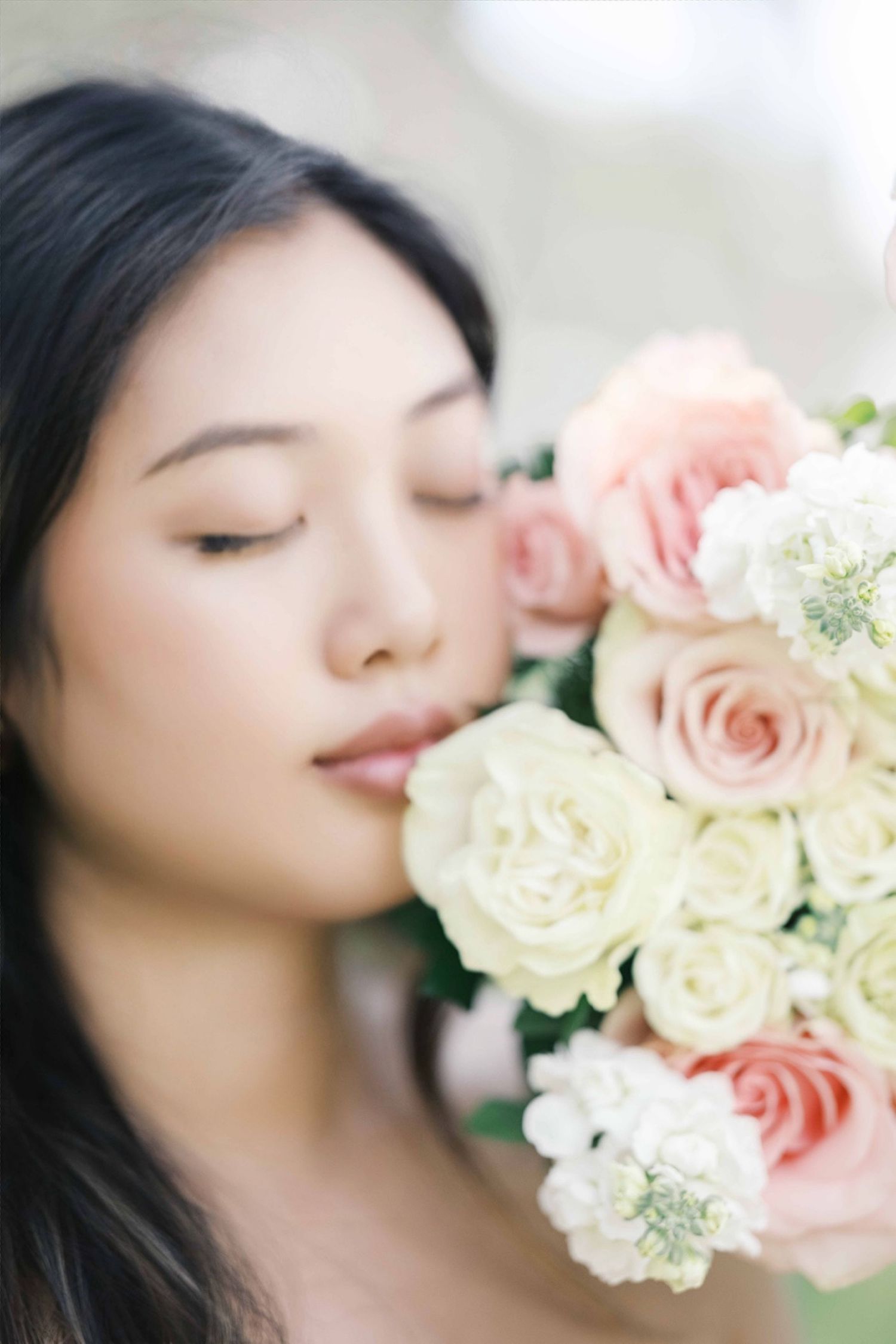 Artistic close-up portrait with soft pink and white roses creating a dreamy, romantic aesthetic. Motherhood london photographer