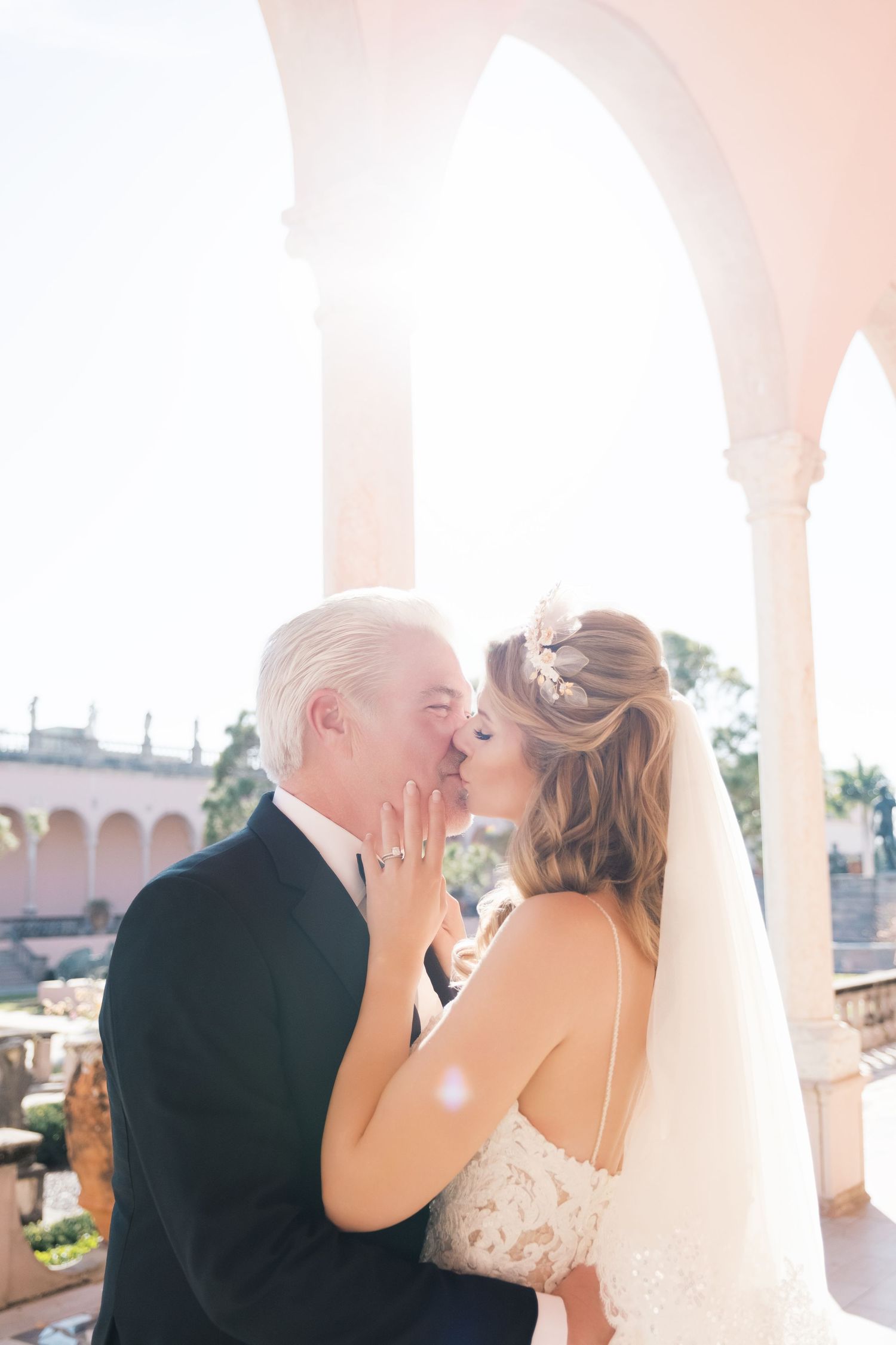 Wedding scene in an elegant white and pink room with ornate architectural details and decorative moldings. London uk photographer