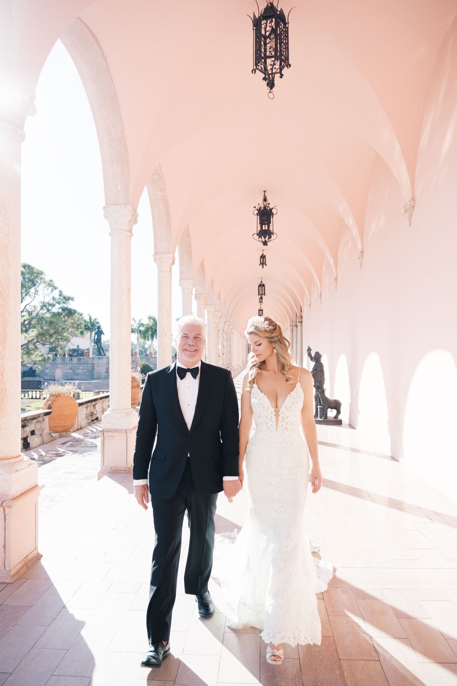 Wedding scene in an elegant white and pink room with ornate architectural details and decorative moldings. London uk photographer