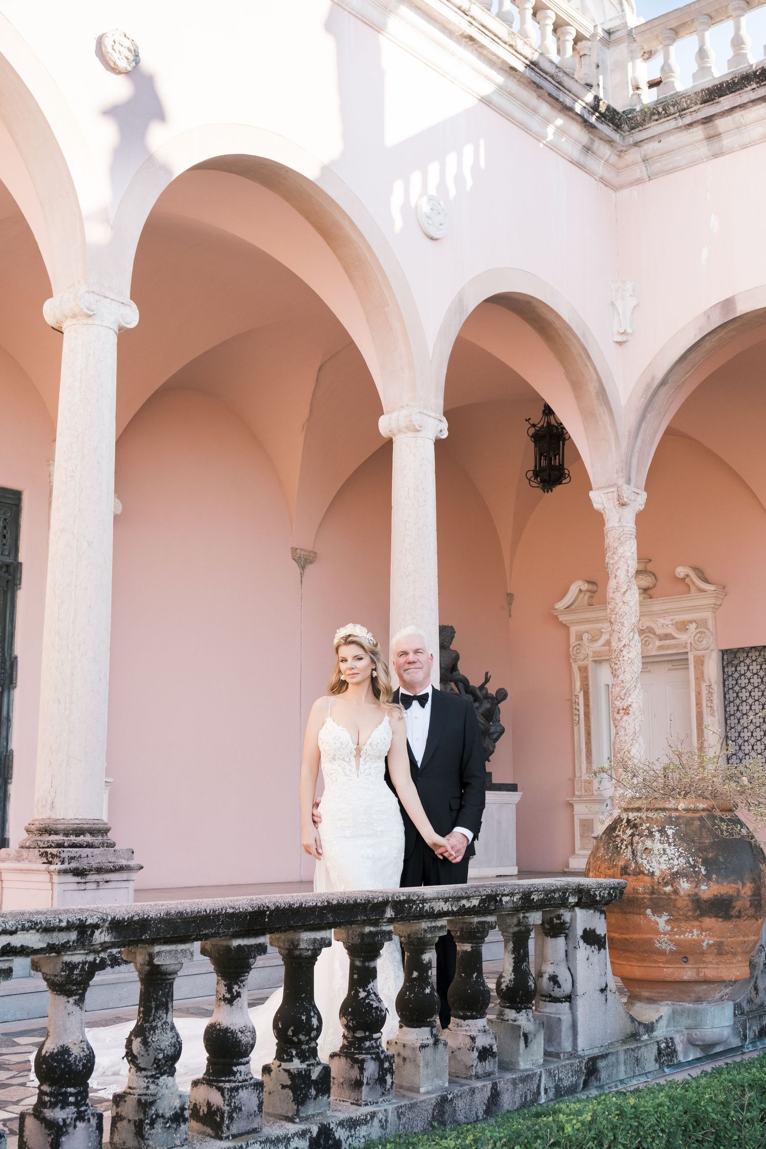 Wedding scene in an elegant white and pink room with ornate architectural details and decorative moldings. London uk photographer