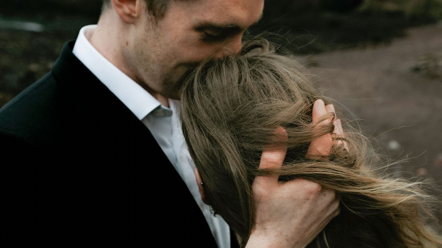 Man kisses the top of a woman's head during romantic couples shoot with Saundra Mouton Photography