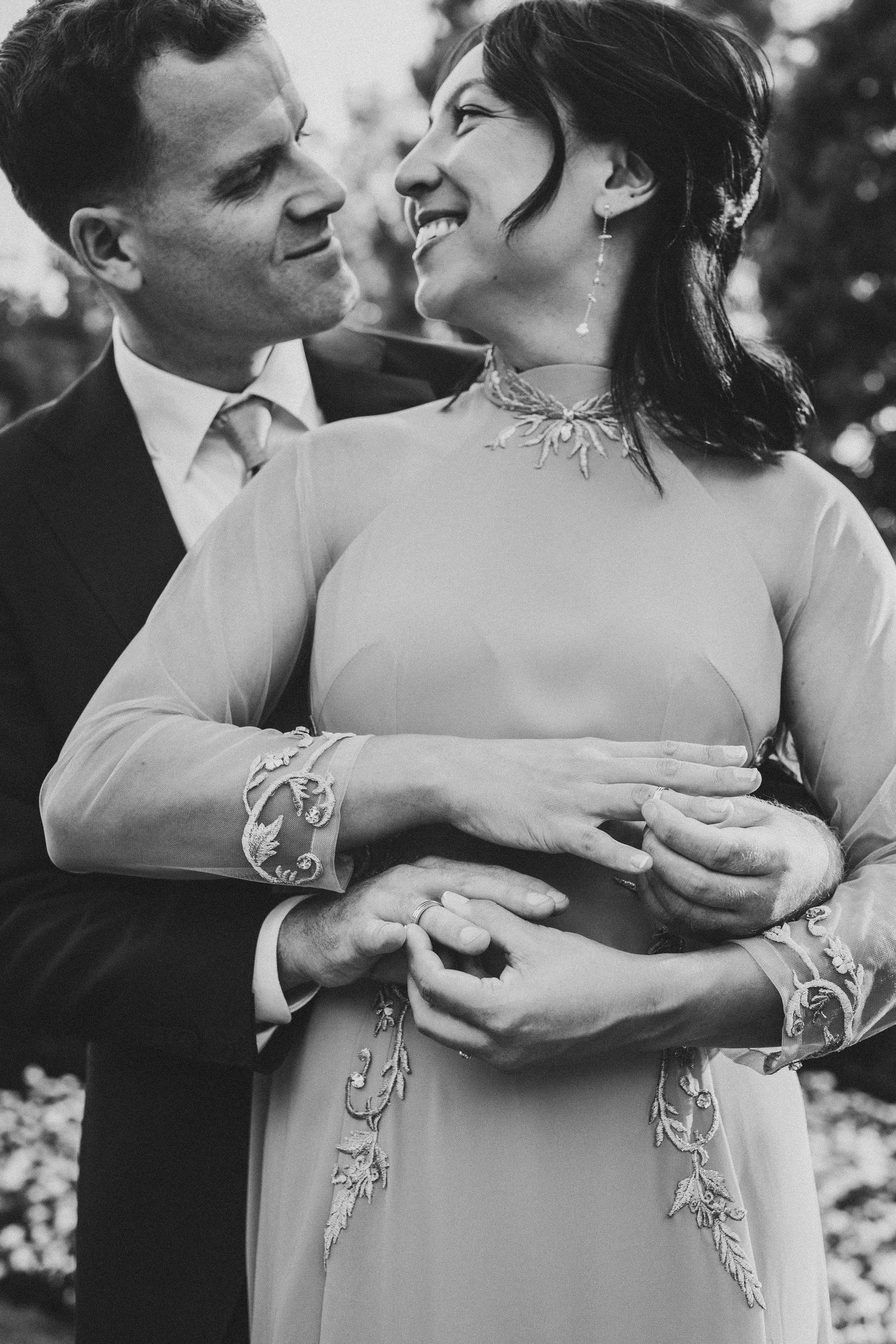 Close-up black and white portrait of a couple embracing in traditional Asian formal attire.