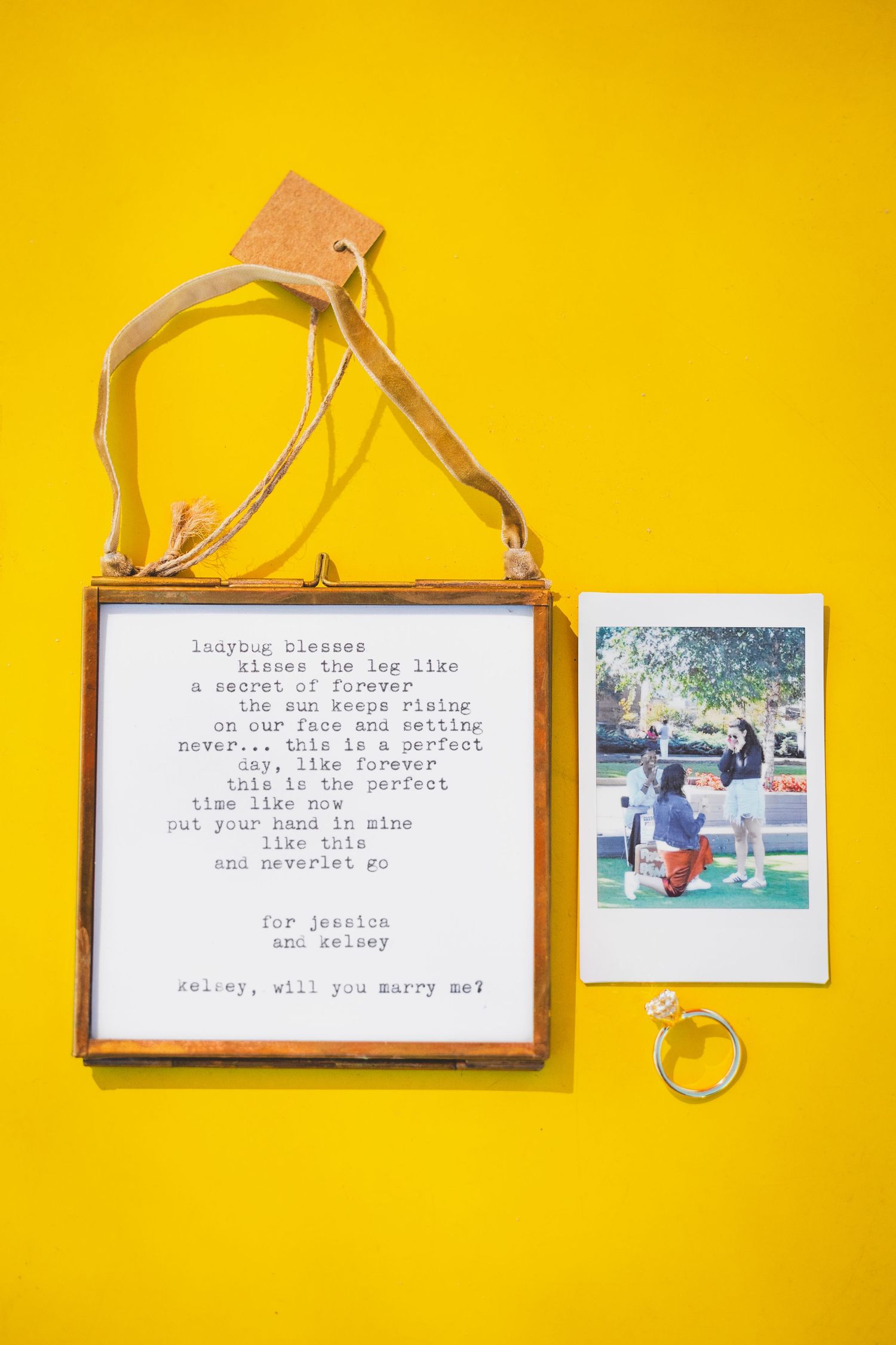 detail shot of engagement ring, polaroid, and love poem