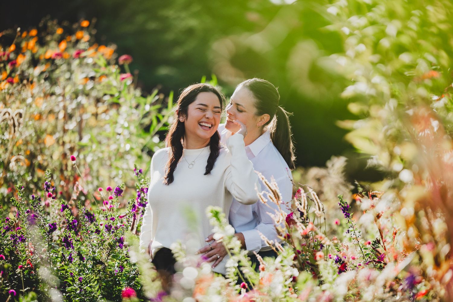 lgbt couple share a joyful moment surrounded by colorful wildflowers at Hillwood Estate