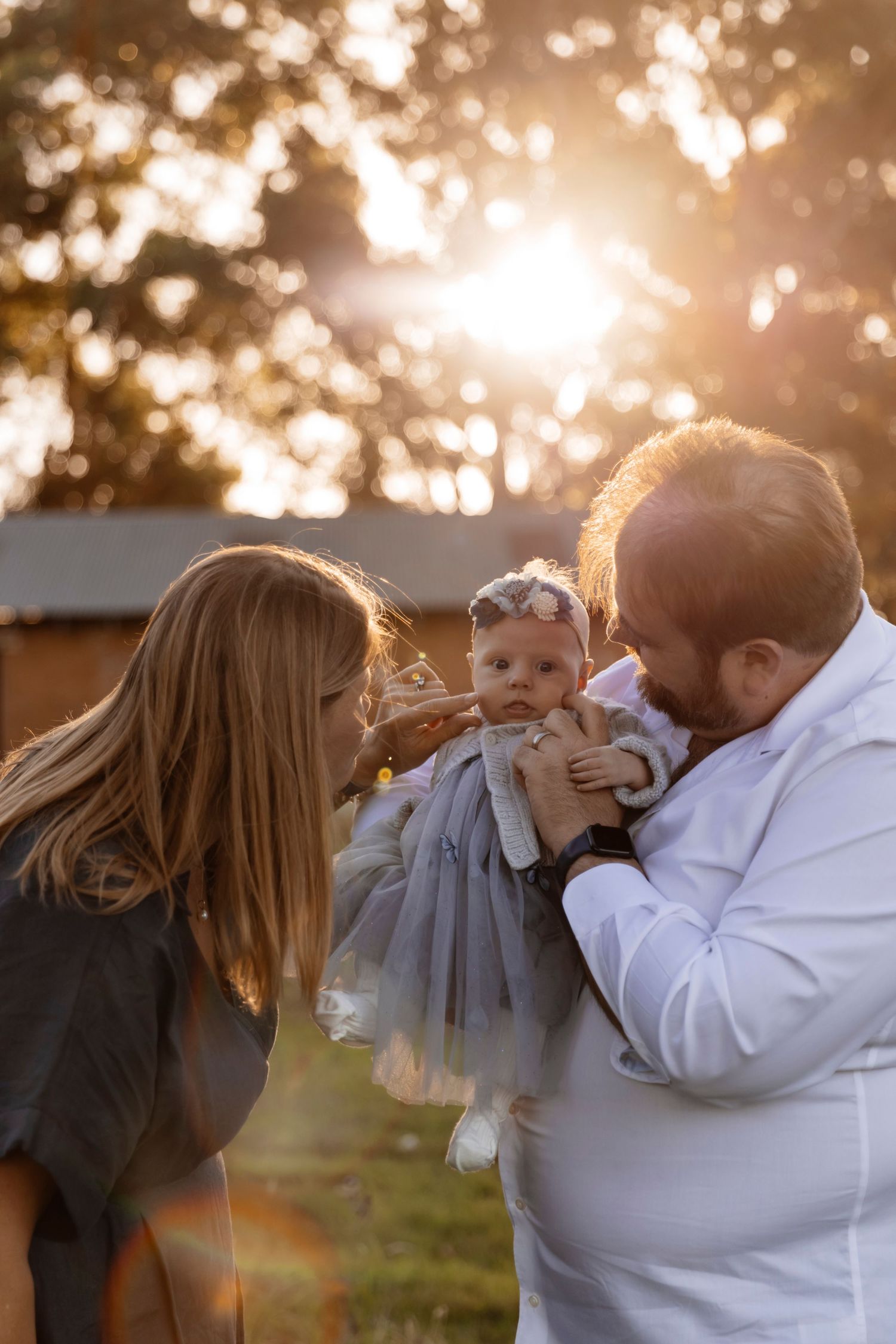 Family holding their baby at sunset, outdoor North Shore family photoshoot