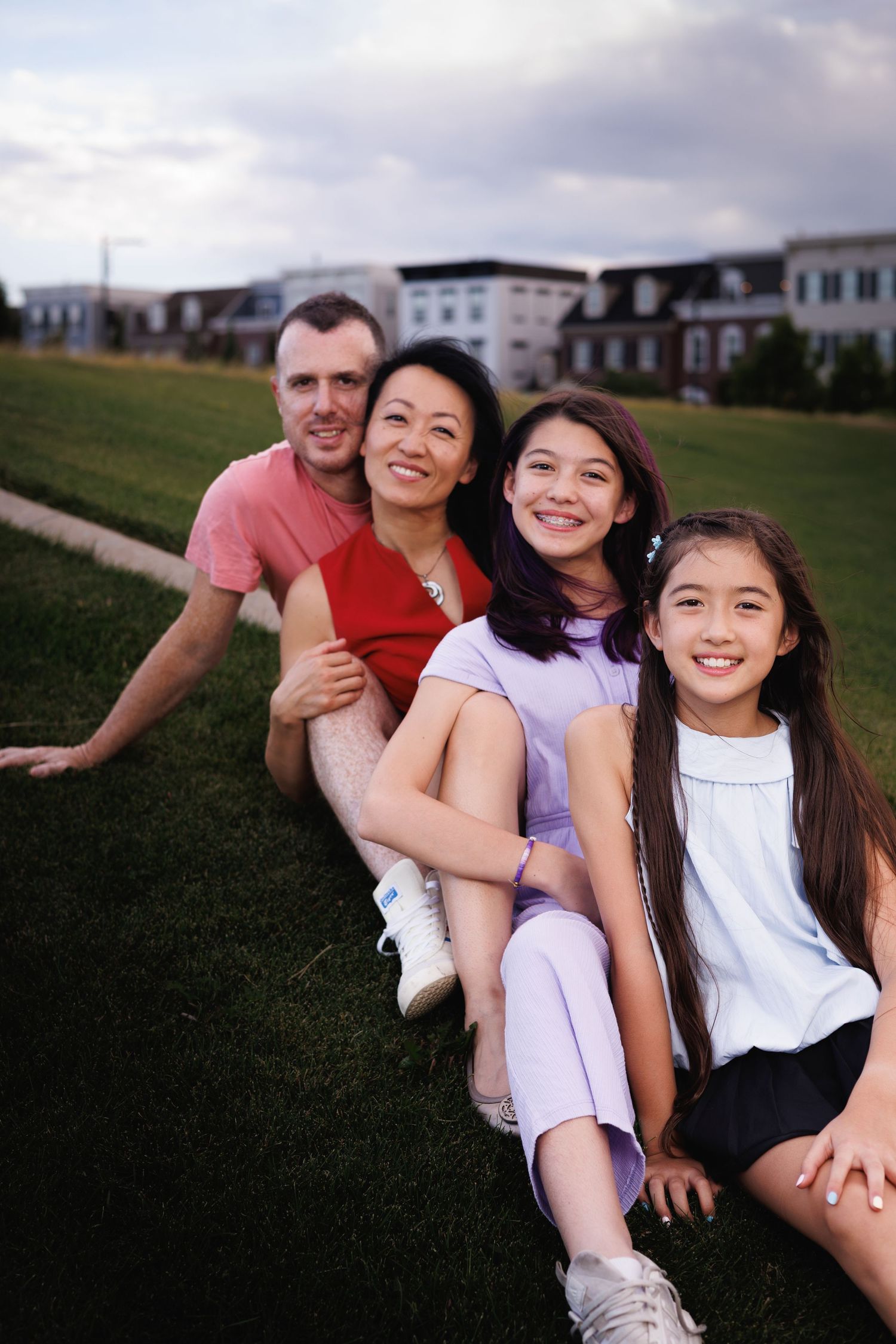 Family of five sitting together on grass at sunset — Littleton, CO family portrait session by Graham Tipton.