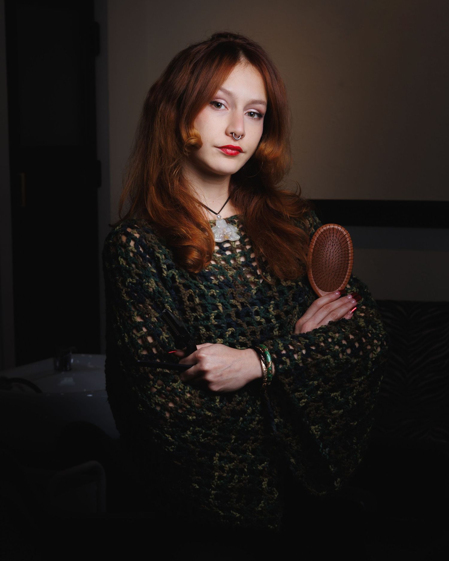 Moody senior portrait of a redhead in a jeweled top holding a hand mirror — Littleton, CO portrait photography.