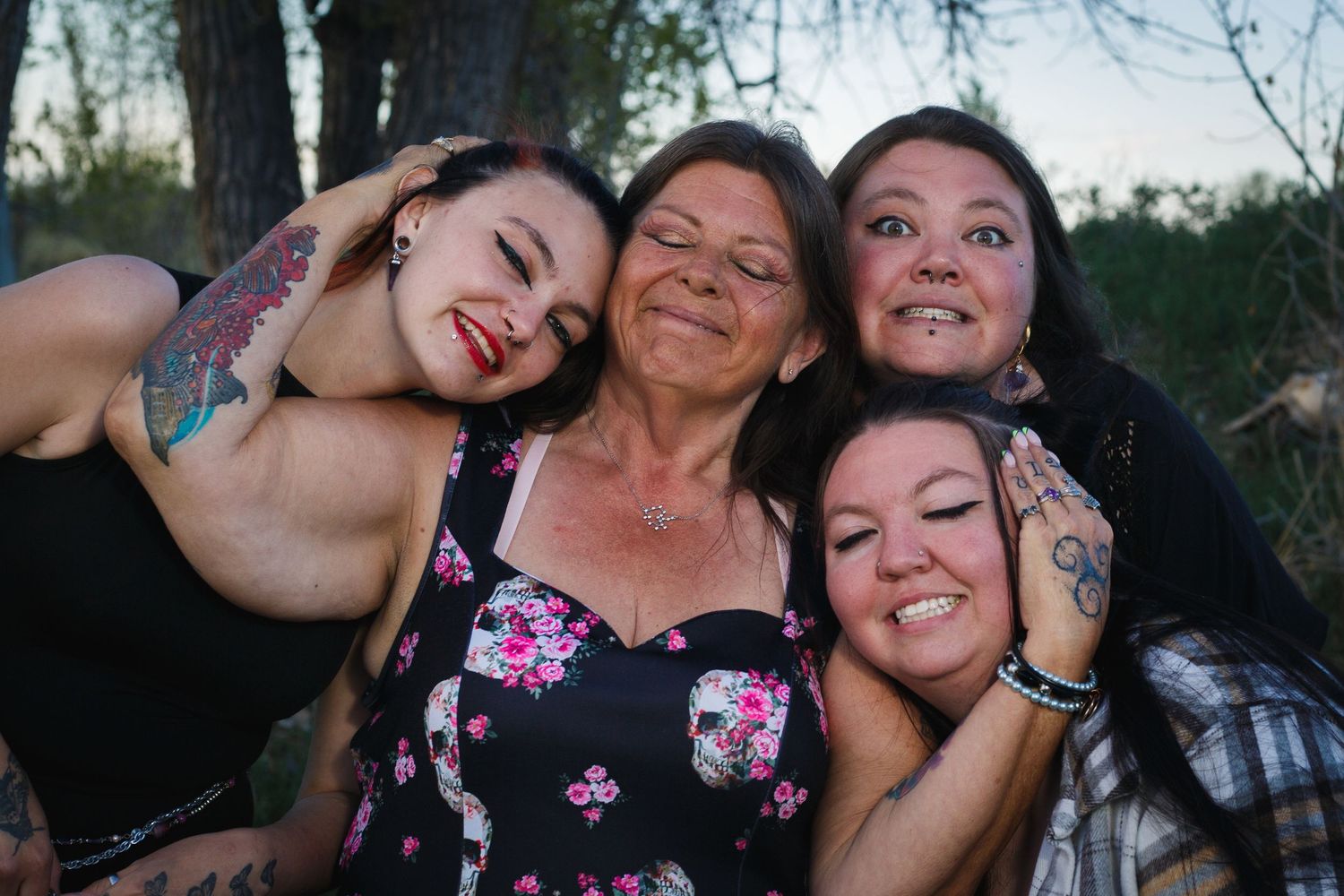 Group of people huddled together, smiling and laughing outdoors.