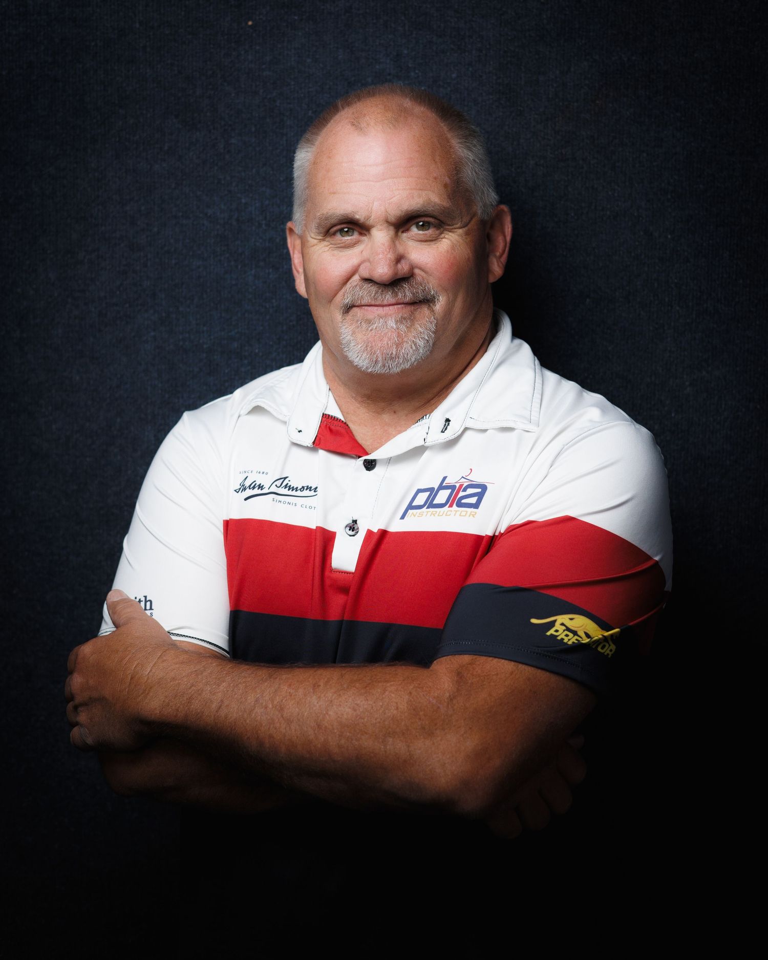 Professional headshot portrait — older man in red, white and blue polo with arms crossed, Littleton, CO portrait photography.