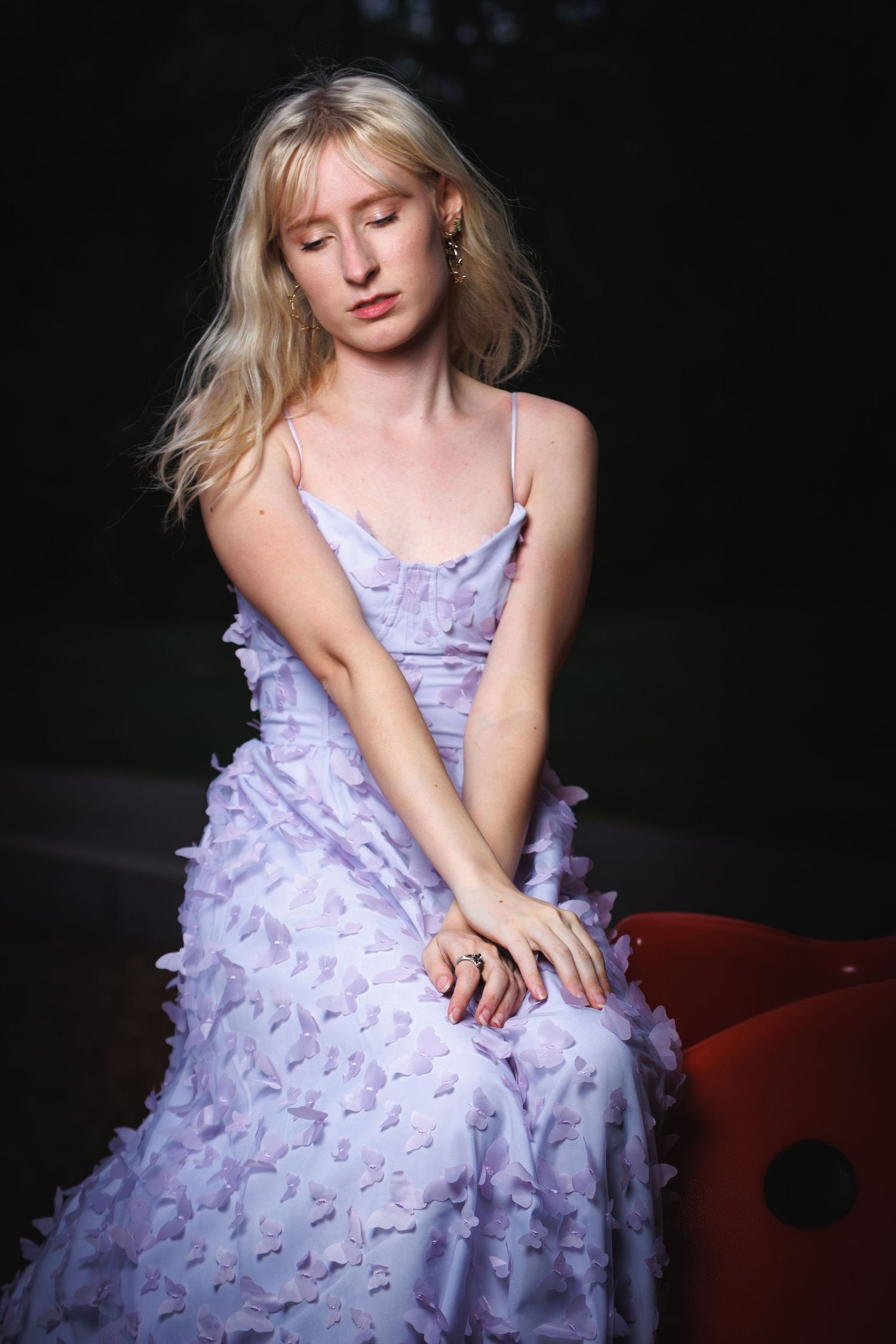 Senior portrait of a blonde woman in a lavender gown with red chair — editorial portrait photography, Littleton, CO.