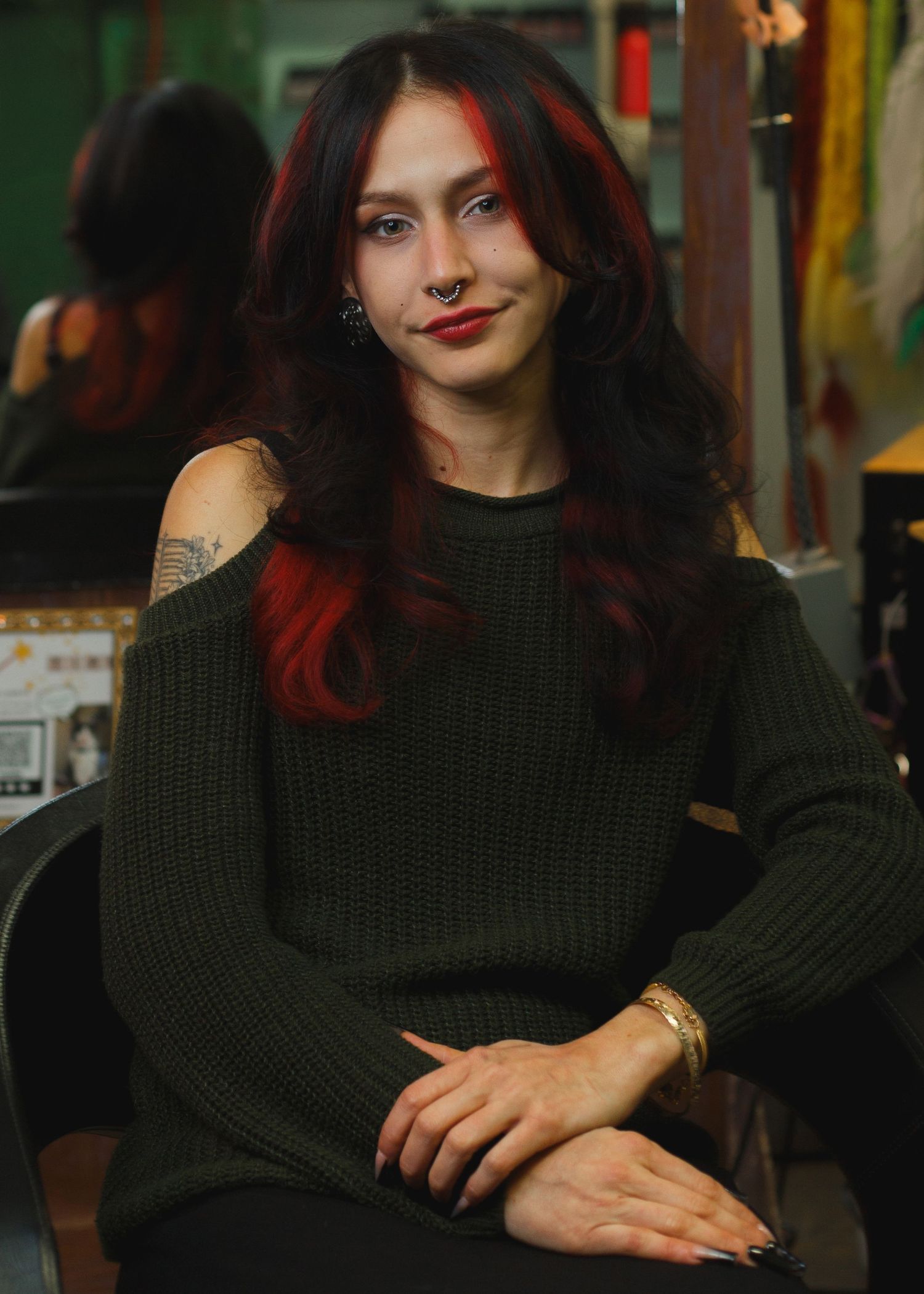 Editorial portrait — woman with long dark hair in a dark green top against warm indoor lighting, Littleton, CO portrait photography.