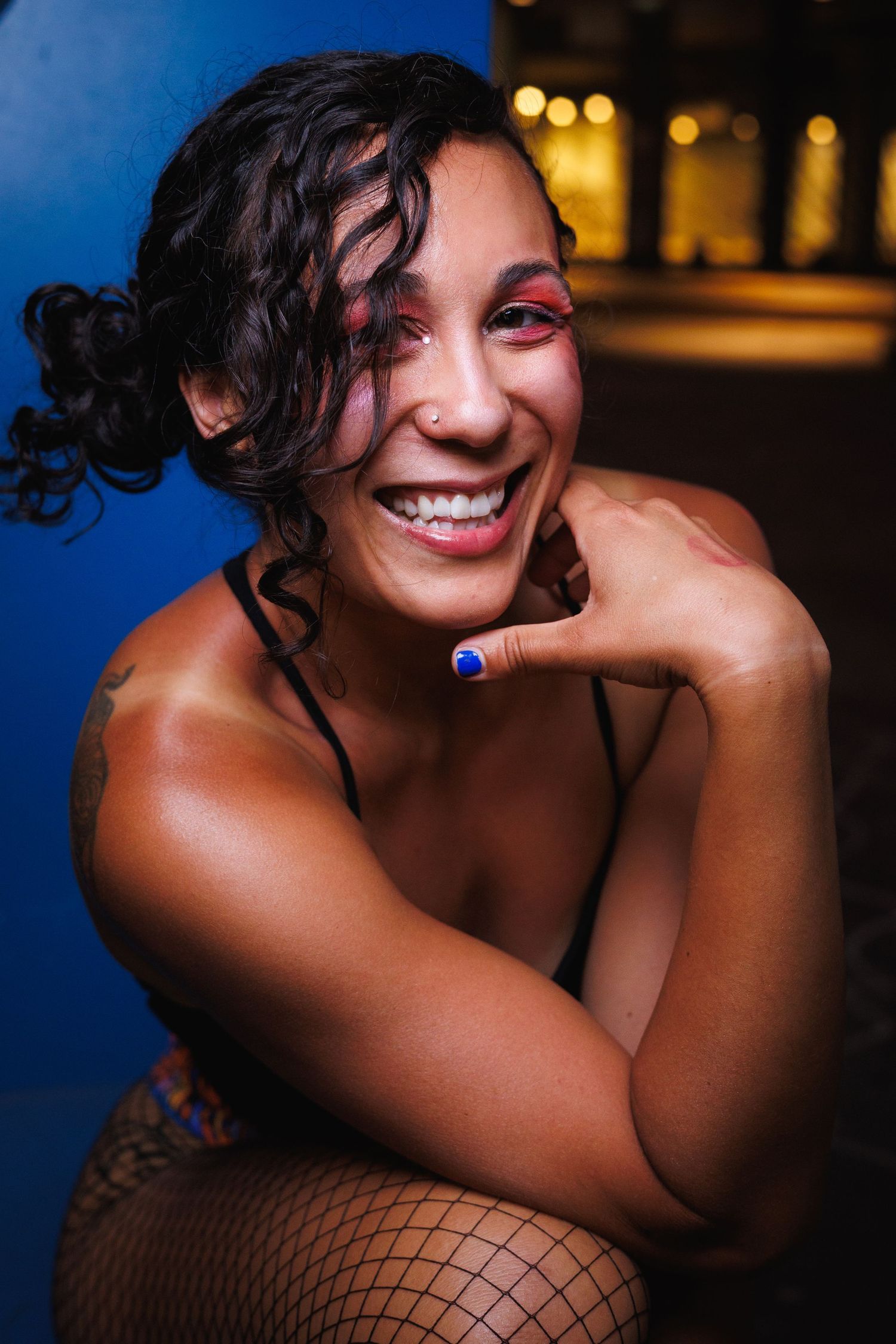 Senior portrait of a woman with curly hair smiling outdoors at golden hour — Littleton, CO senior photography.