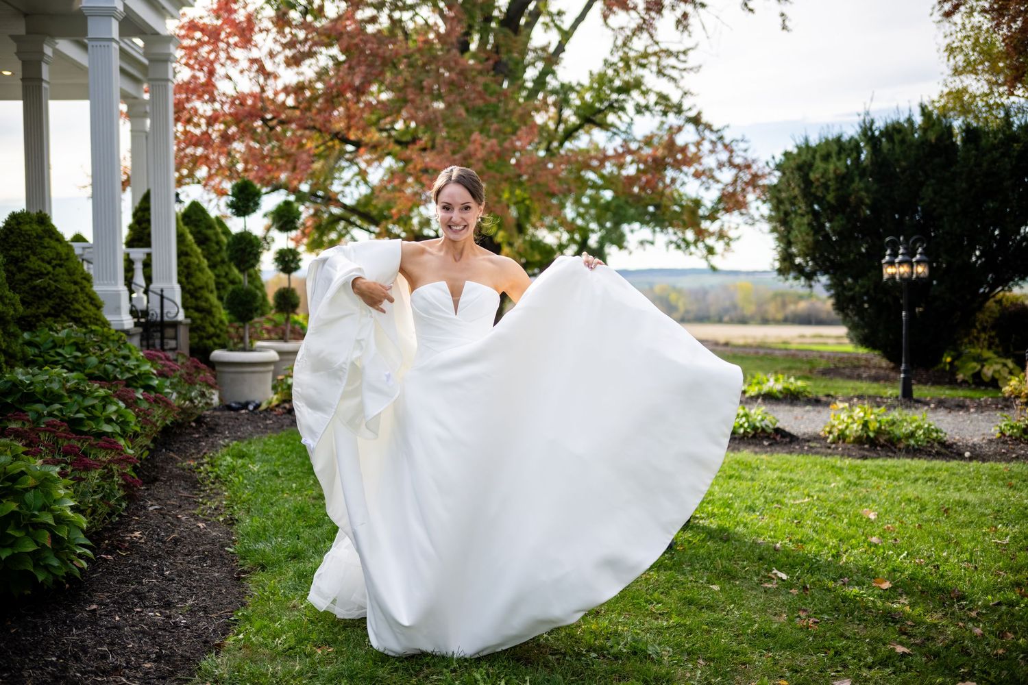 A flowing white wedding dress swirls gracefully during a romantic outdoor autumn photo session.