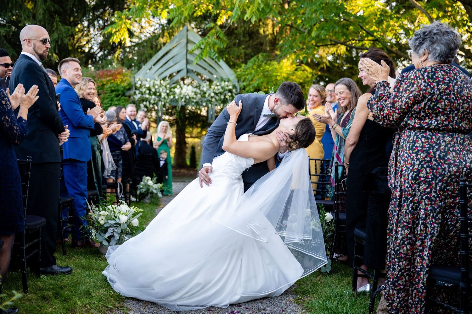 Bride & groom's first kiss at the altar, John Joseph Inn, Groton, NY. Light and airy outdoor ceremony photography by Allison Mott.