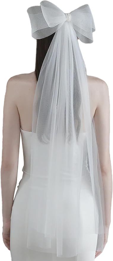 Back view of wedding veil with large sheer white bow attached to a white dress.