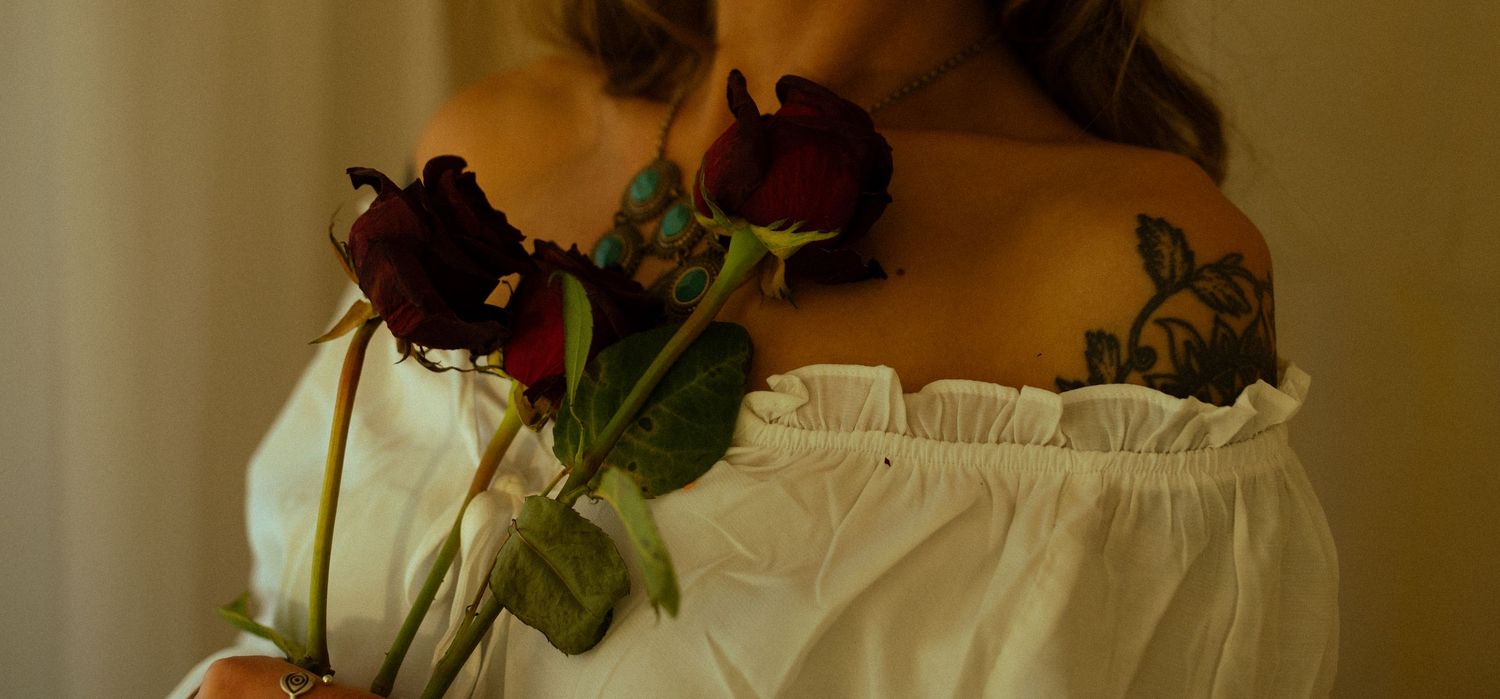 Deep red roses against soft fabric in warm, moody lighting.
