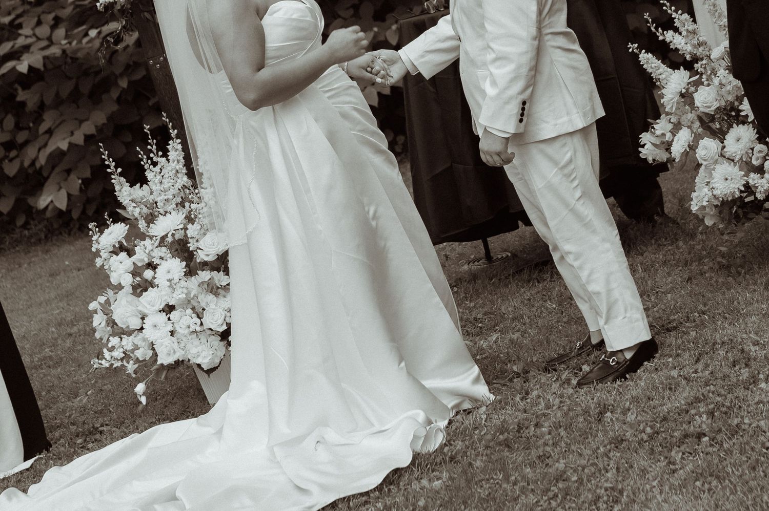 Wedding couple shares an intimate moment surrounded by floral decorations.