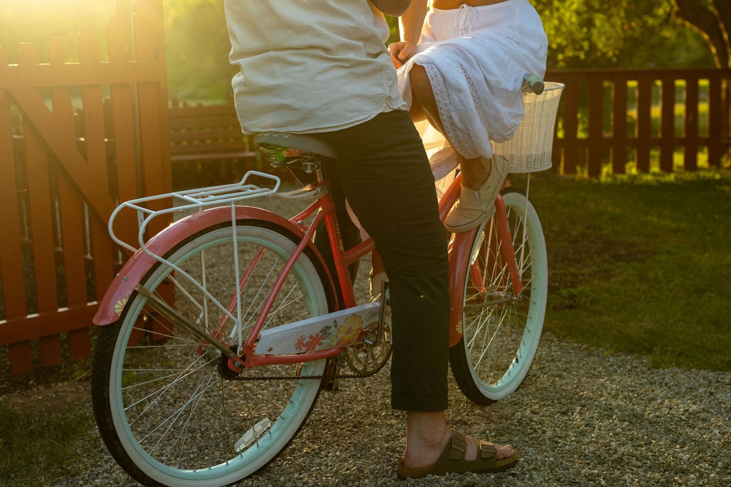 Vintage bicycle silhouetted against golden sunset light in a backyard.