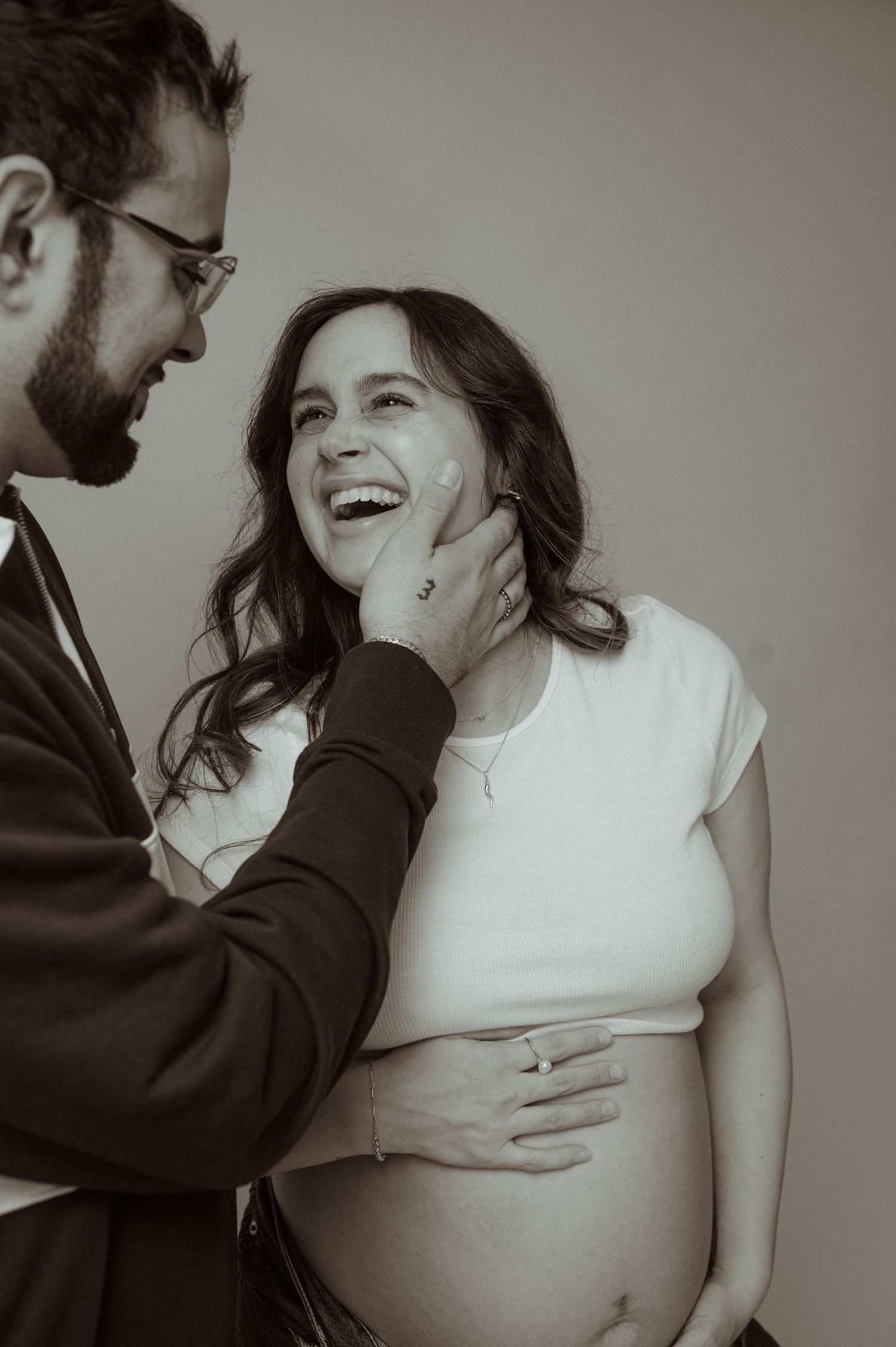 An intimate black and white maternity photoshoot showing tender moments between partners.