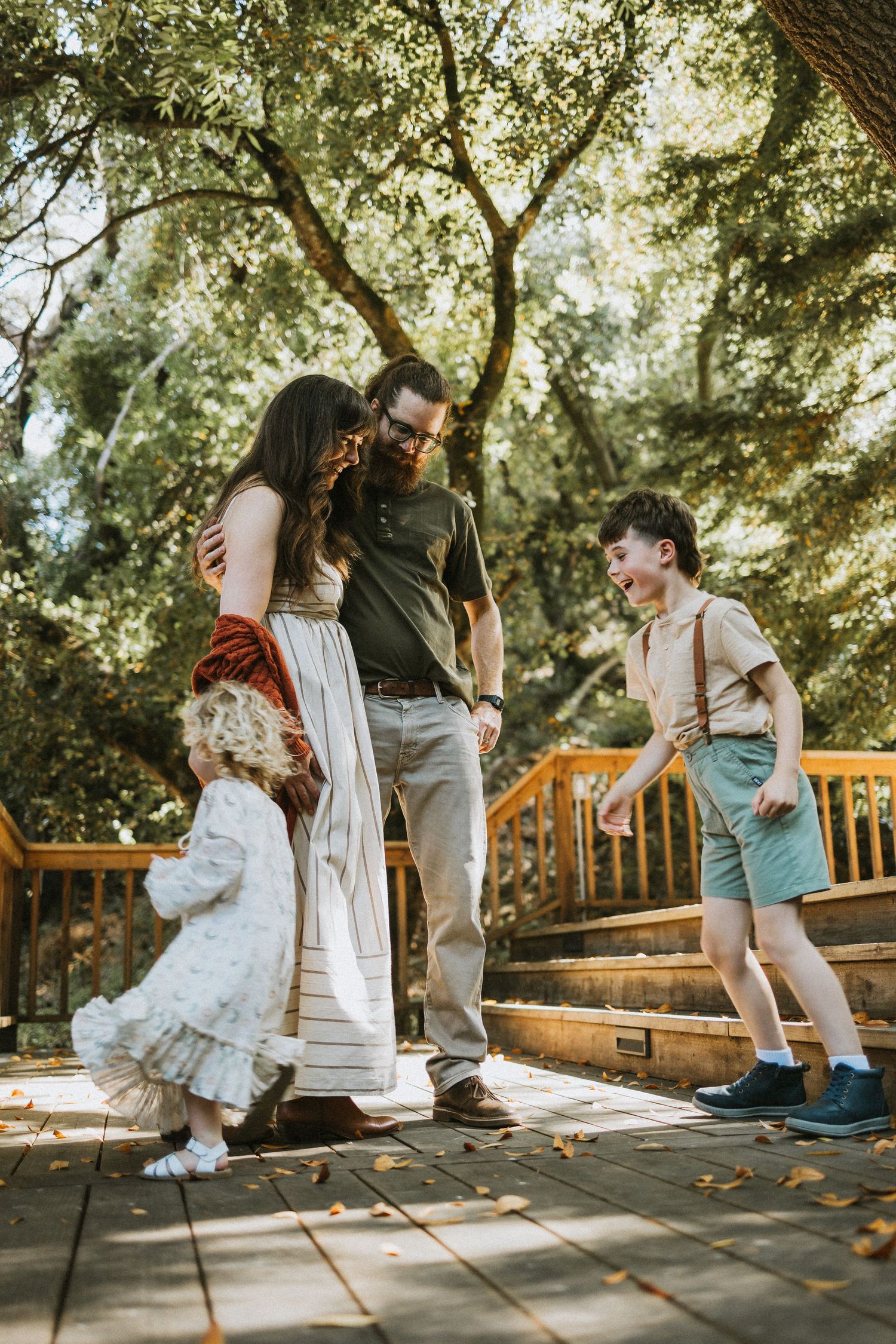 A joyful dance sequence captured on a wooden deck surrounded by lush greenery.