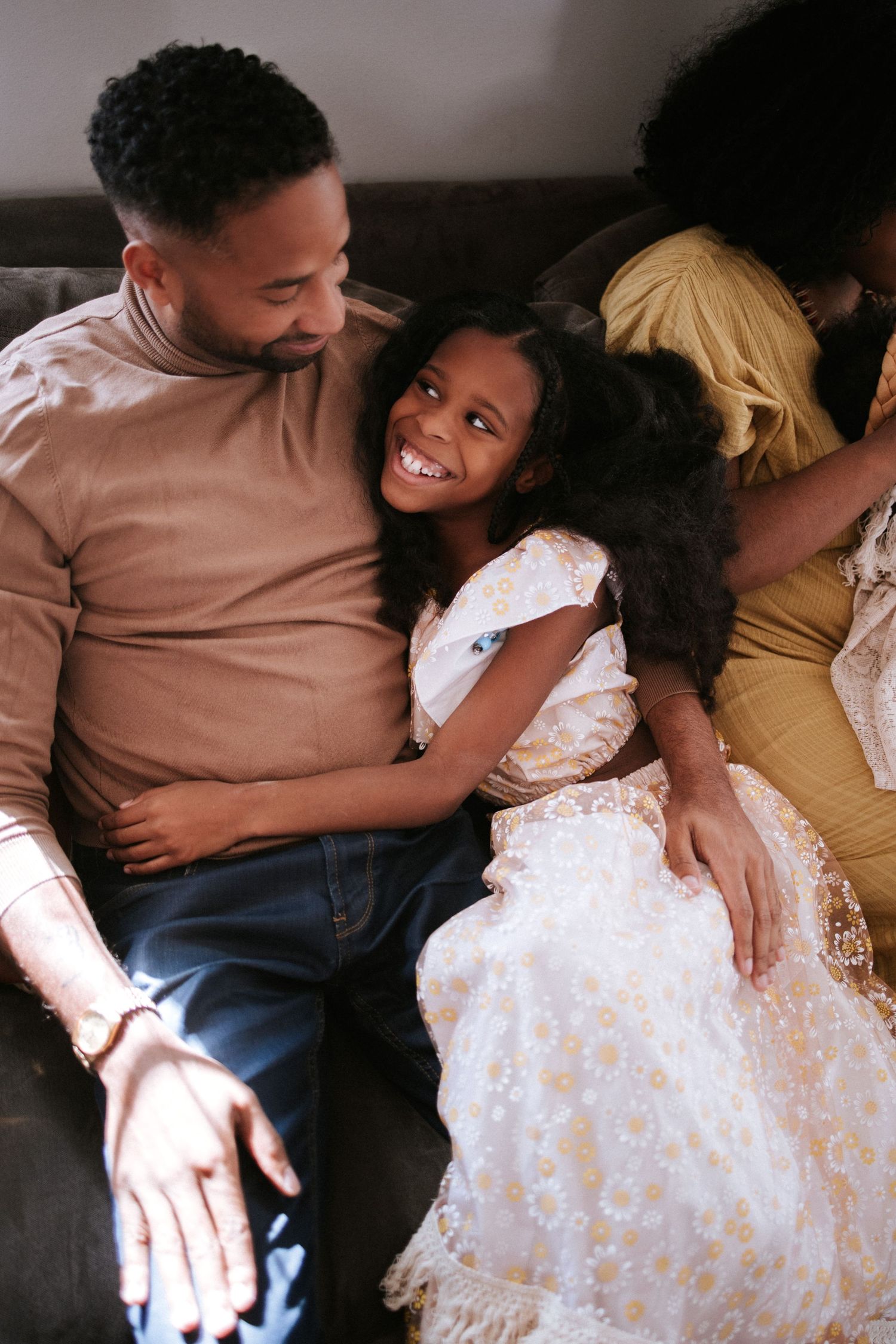 Intimate family moment shared on a couch in warm lighting.