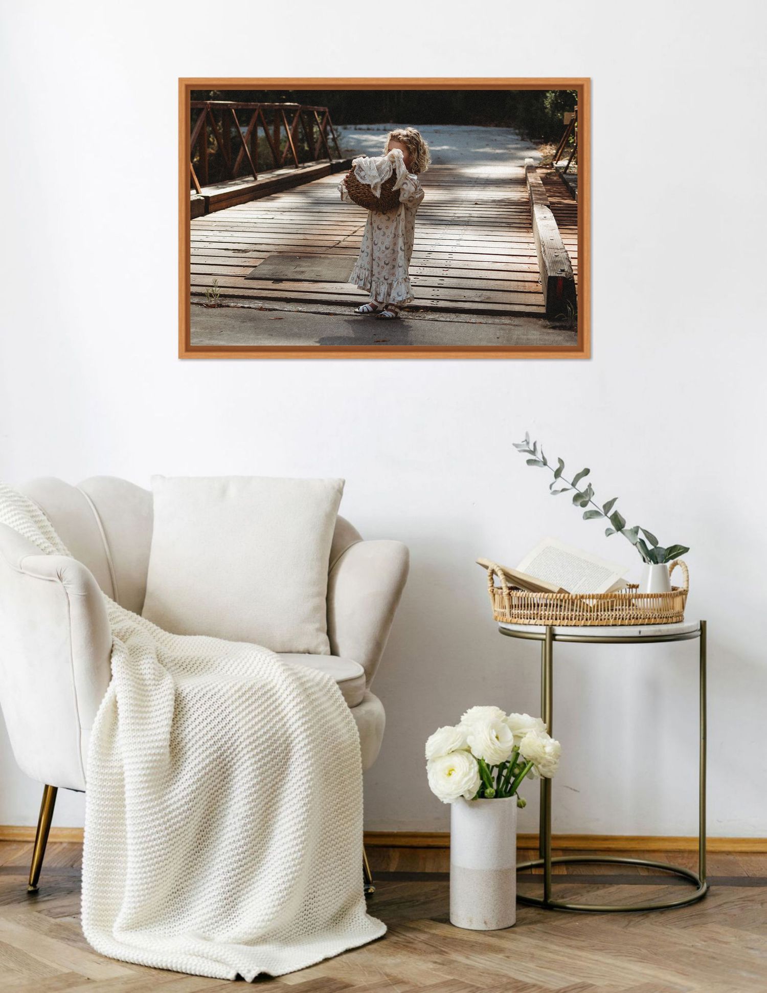 White knit throw blanket draped over furniture in minimalist room setting and framed archival print of little girl holding basket.