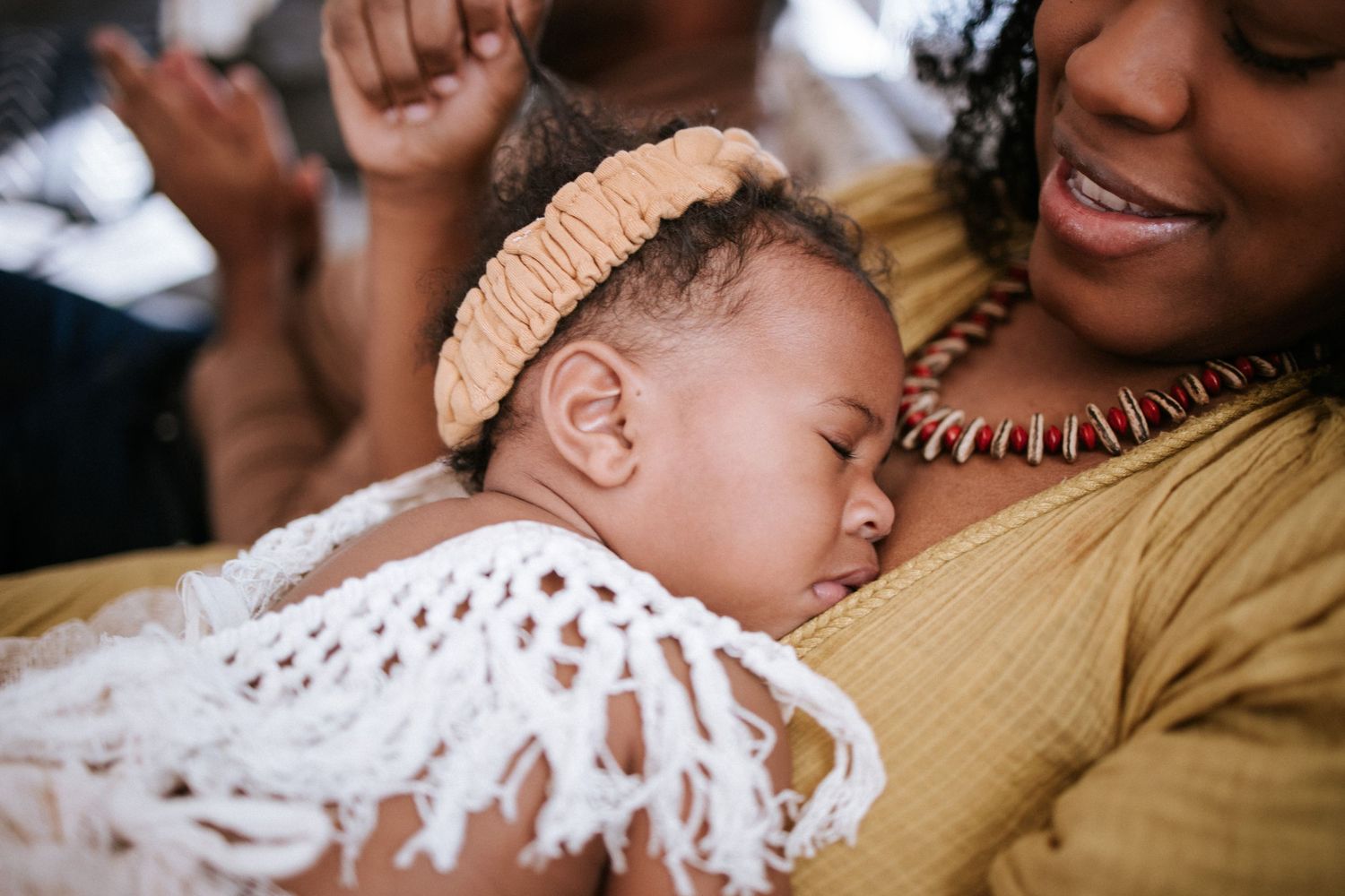 Tender moment captured between parent and infant in warm natural light.