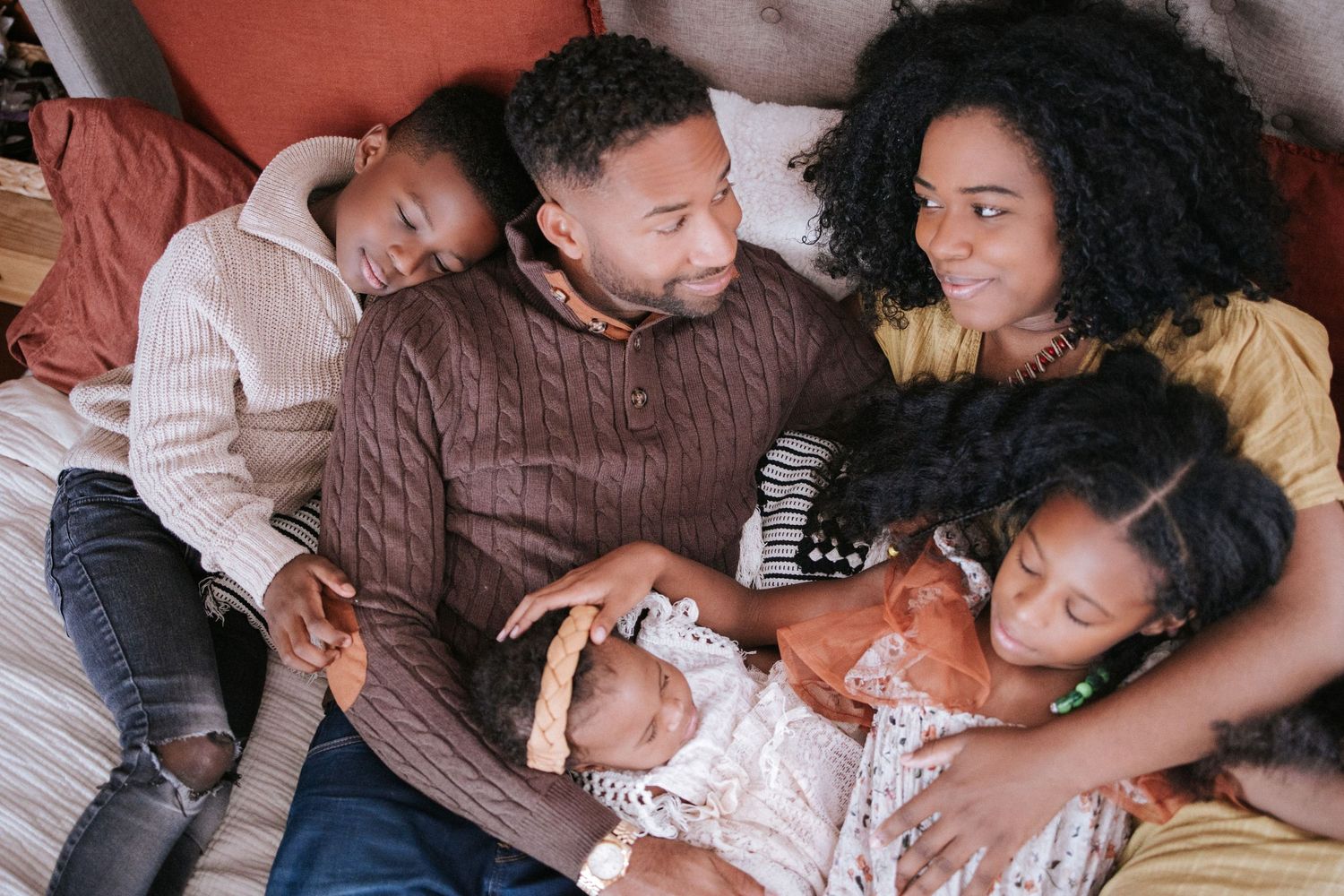 Intimate family portrait showing affectionate moments on a couch.